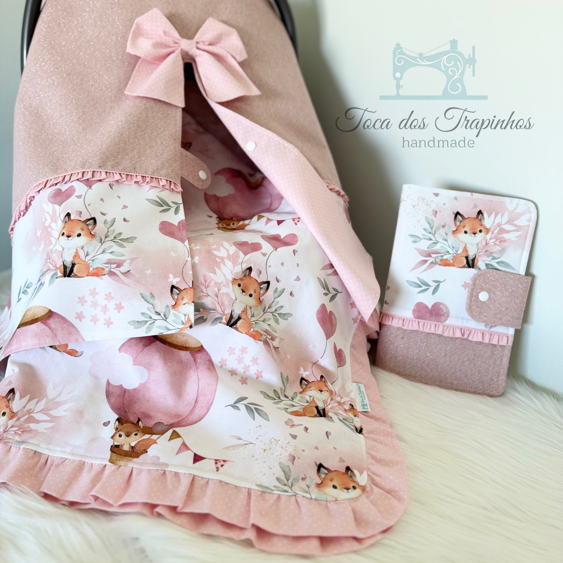 Cama rosa com padrão de raposas e carteira com padrão combinando.