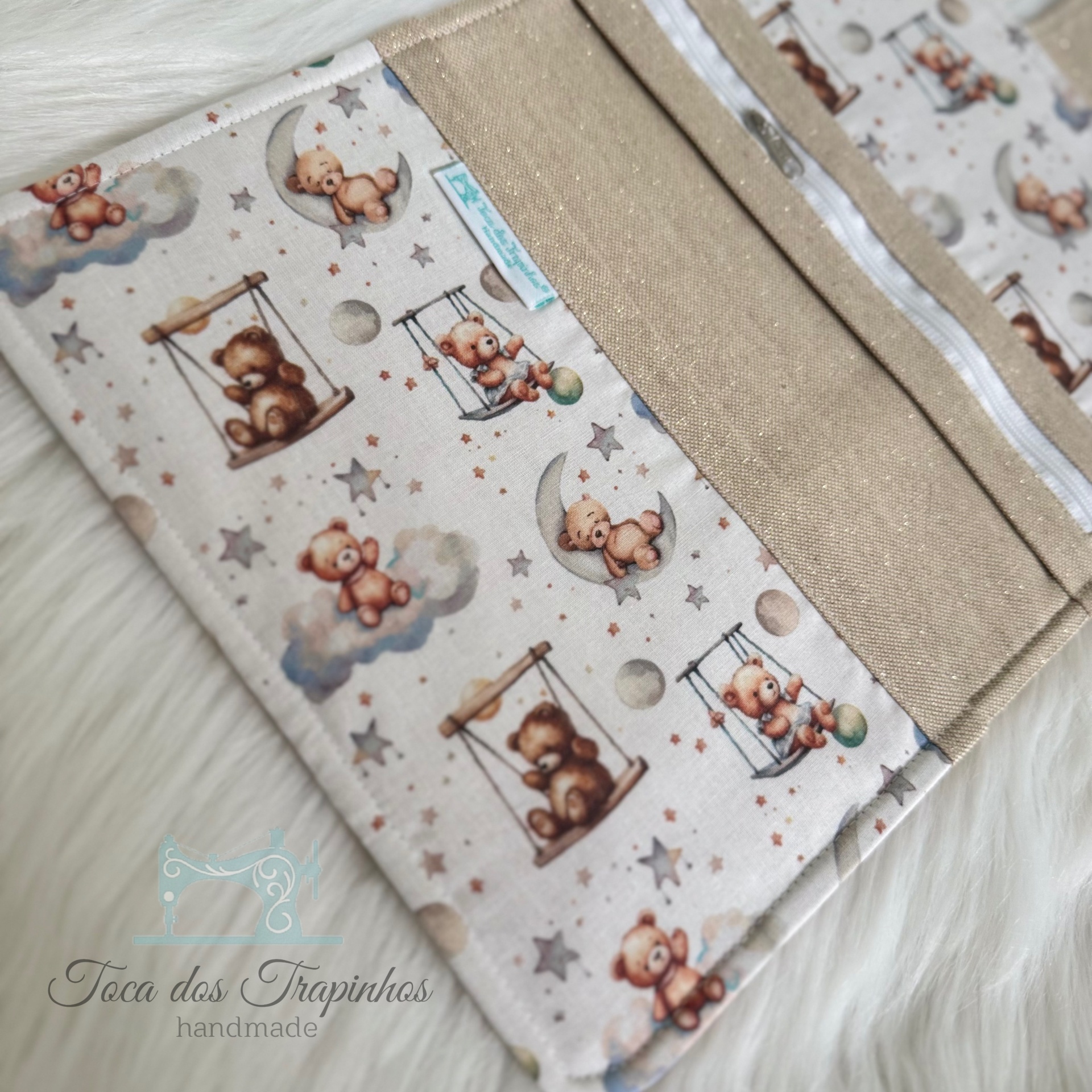 Manta infantil com padrão de ursos em balanço e faixa bege