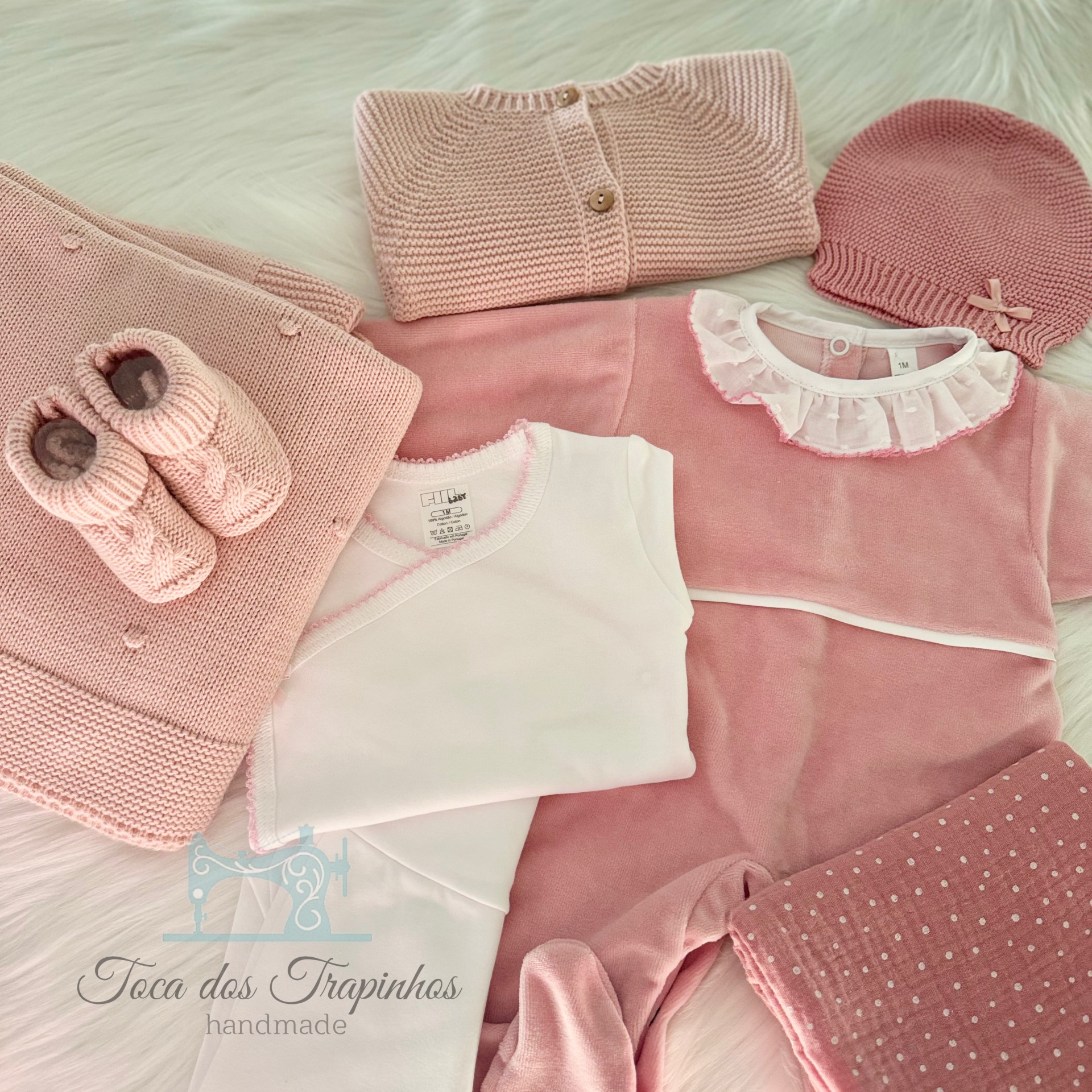 Roupa de bebé rosa com casaquinho de malha, gorro, botinhas e manta