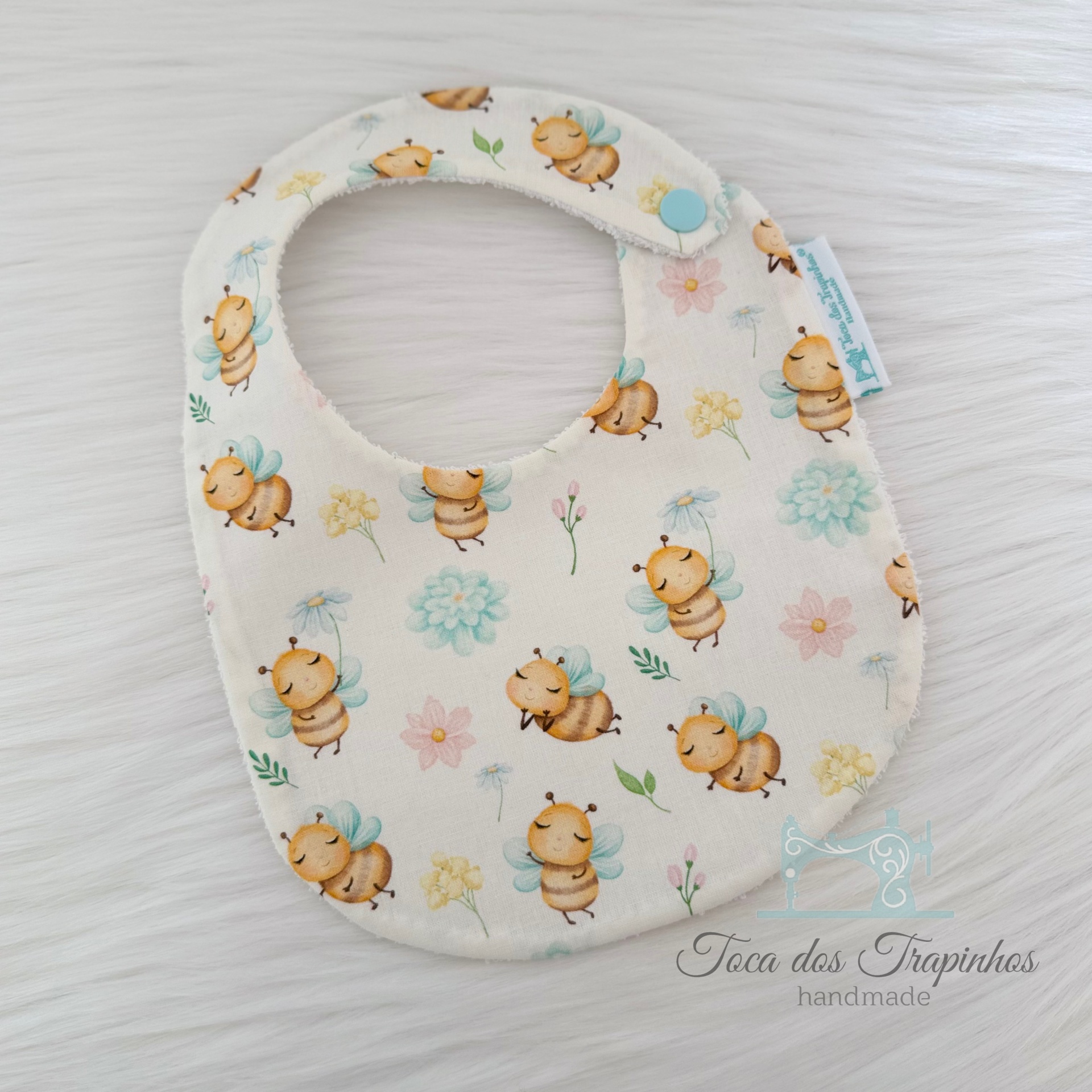 Babete para bebé com padrão de abelhas e flores em tecido branco