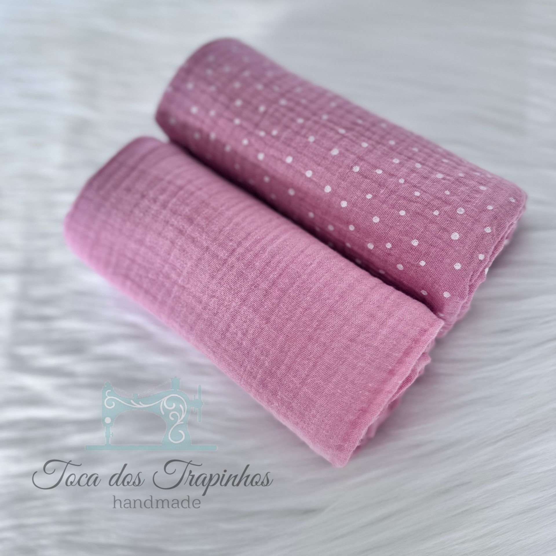 tecidos dobrados rosa com padrão de pontos e textura sobre fundo branco felpudo