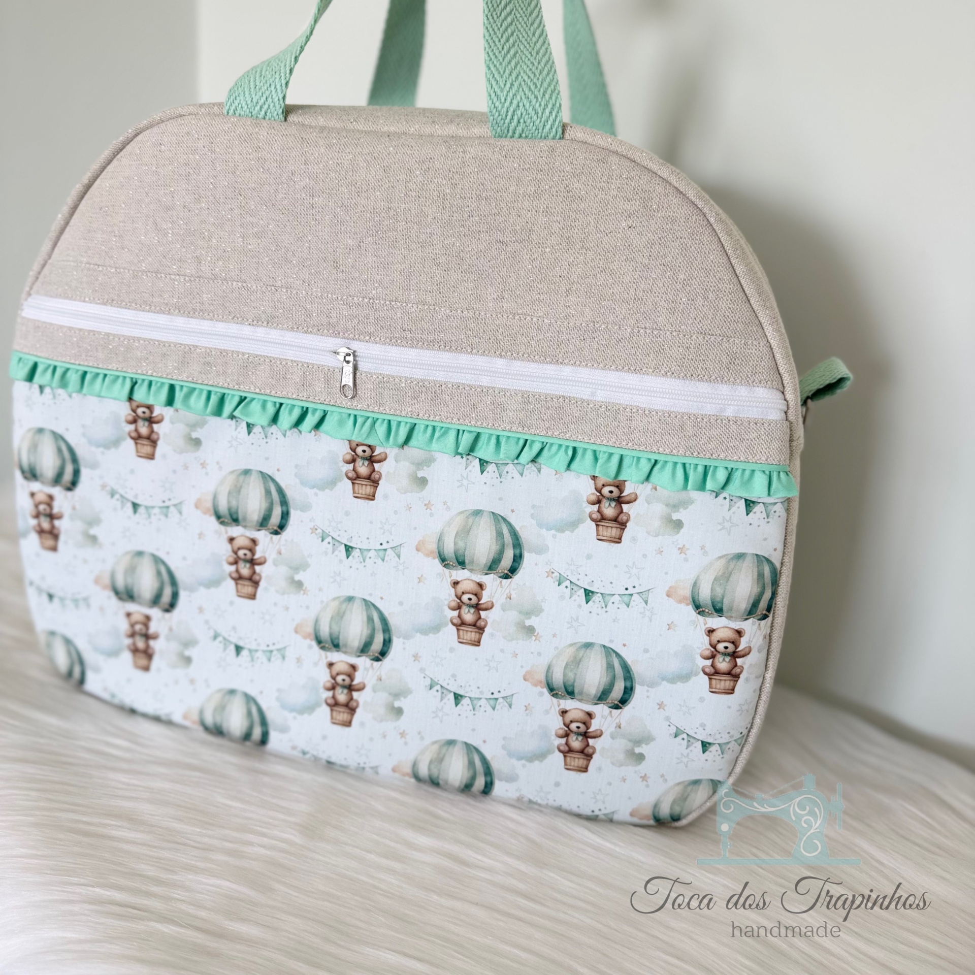 Mala de tecido bege com bolso frontal decorado com padrão de ursinhos em balões