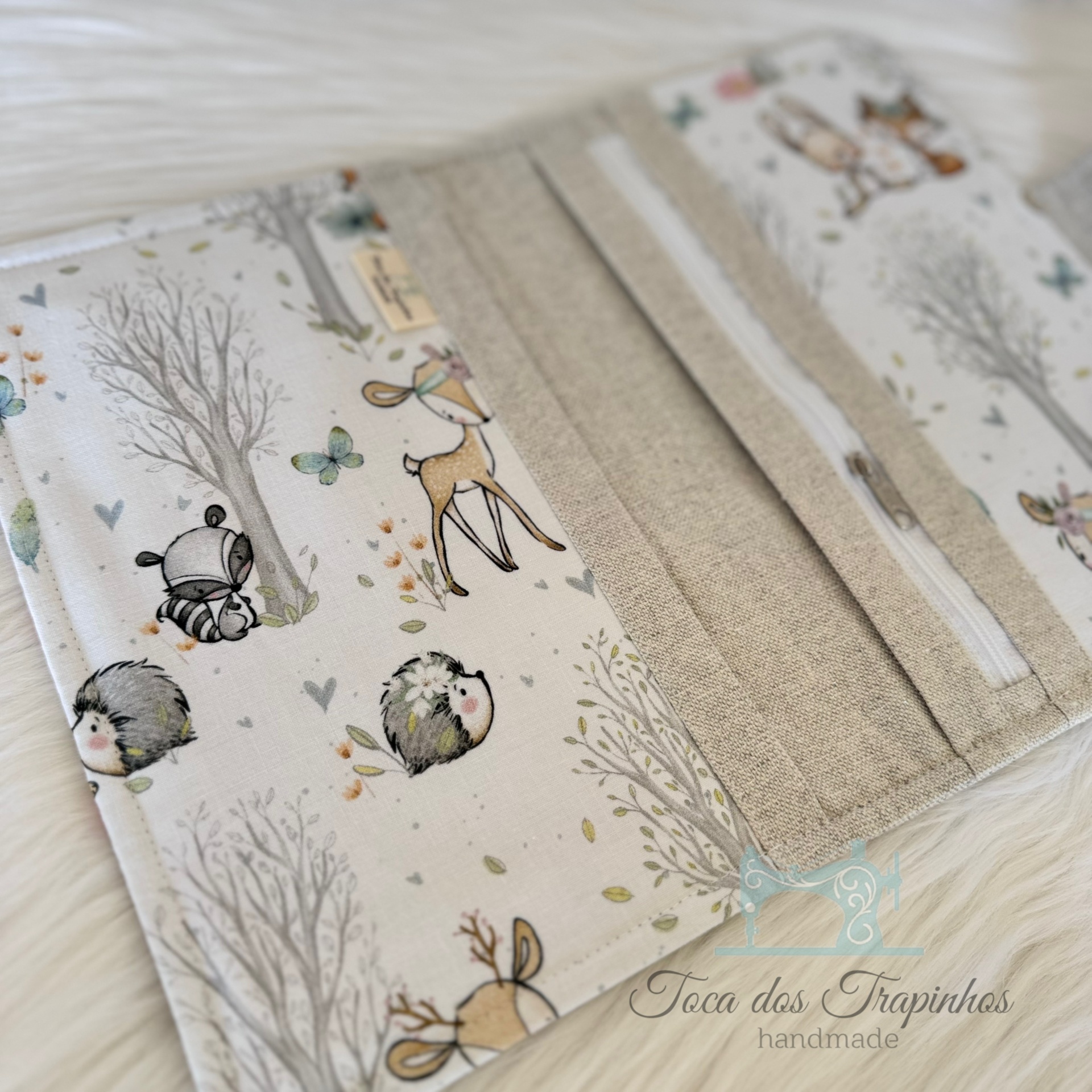 Carteira de tecido com padrão de animais cartoon e fecho branco em fundo branco felpudo