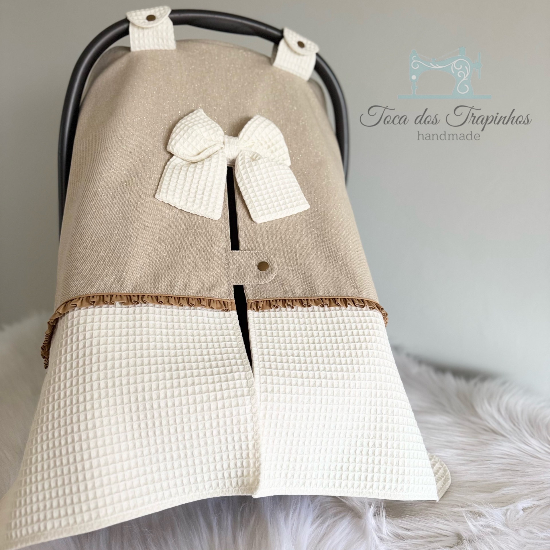 Capa bege e branca para carrinho de bebé com laço branco e folhos castanhos