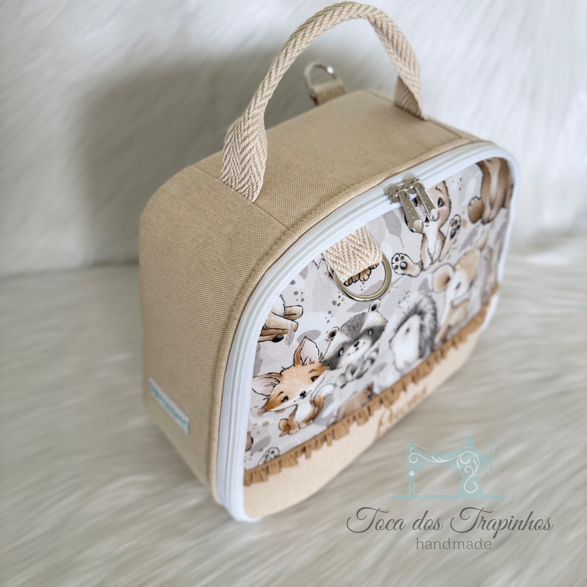 Bolsa creme com padrão de animais em tecido e fecho branco