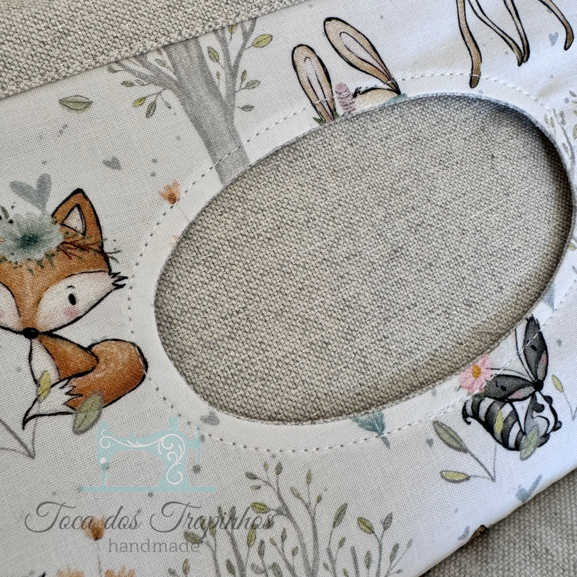 Suporte para máscara com desenhos de animais e plantas sobre fundo branco.