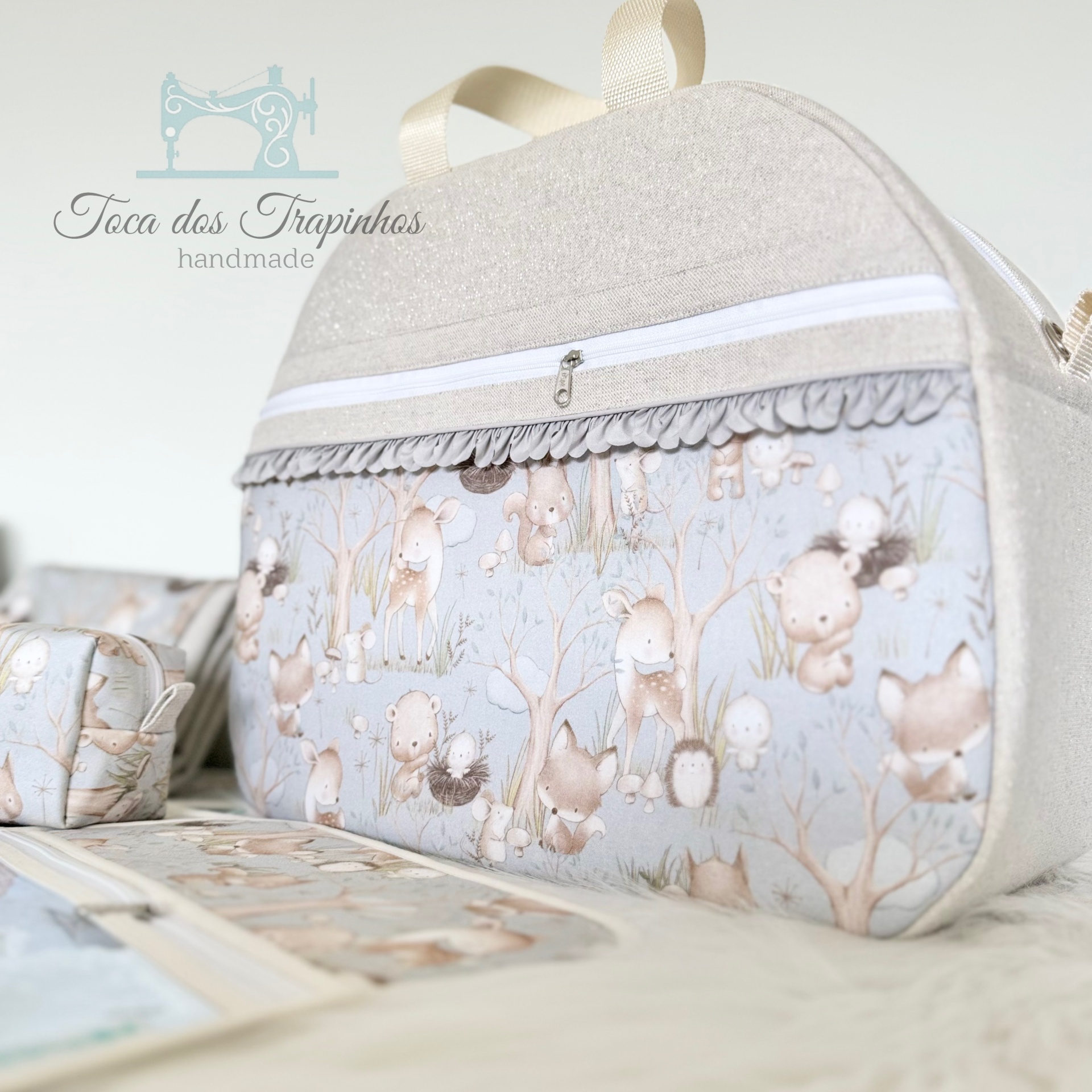 Bolsa tecido padrão animais floresta tons pastel com zíper branco e detalhe franzido