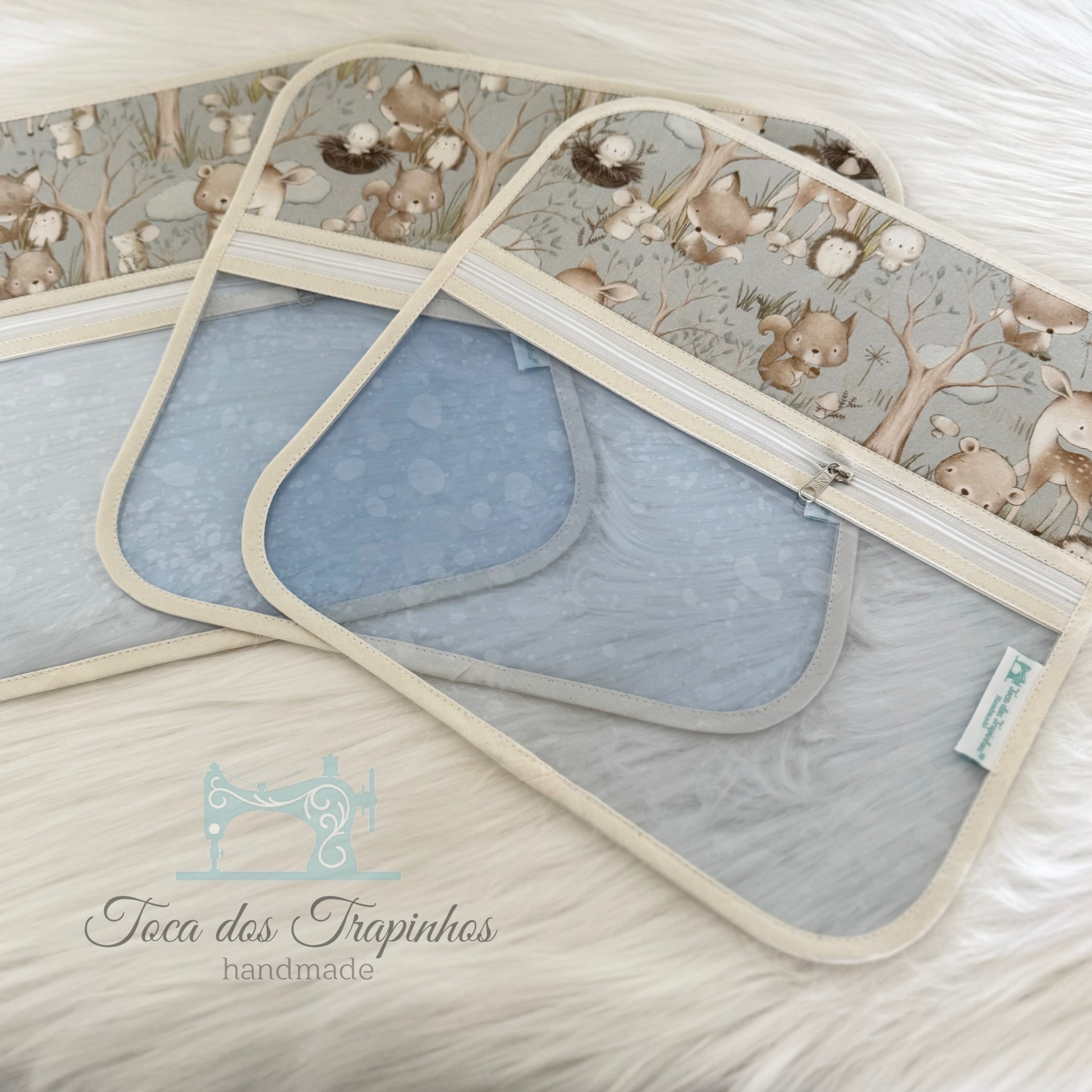 Sacos organizadores transparentes com topo estampado de animais da floresta.