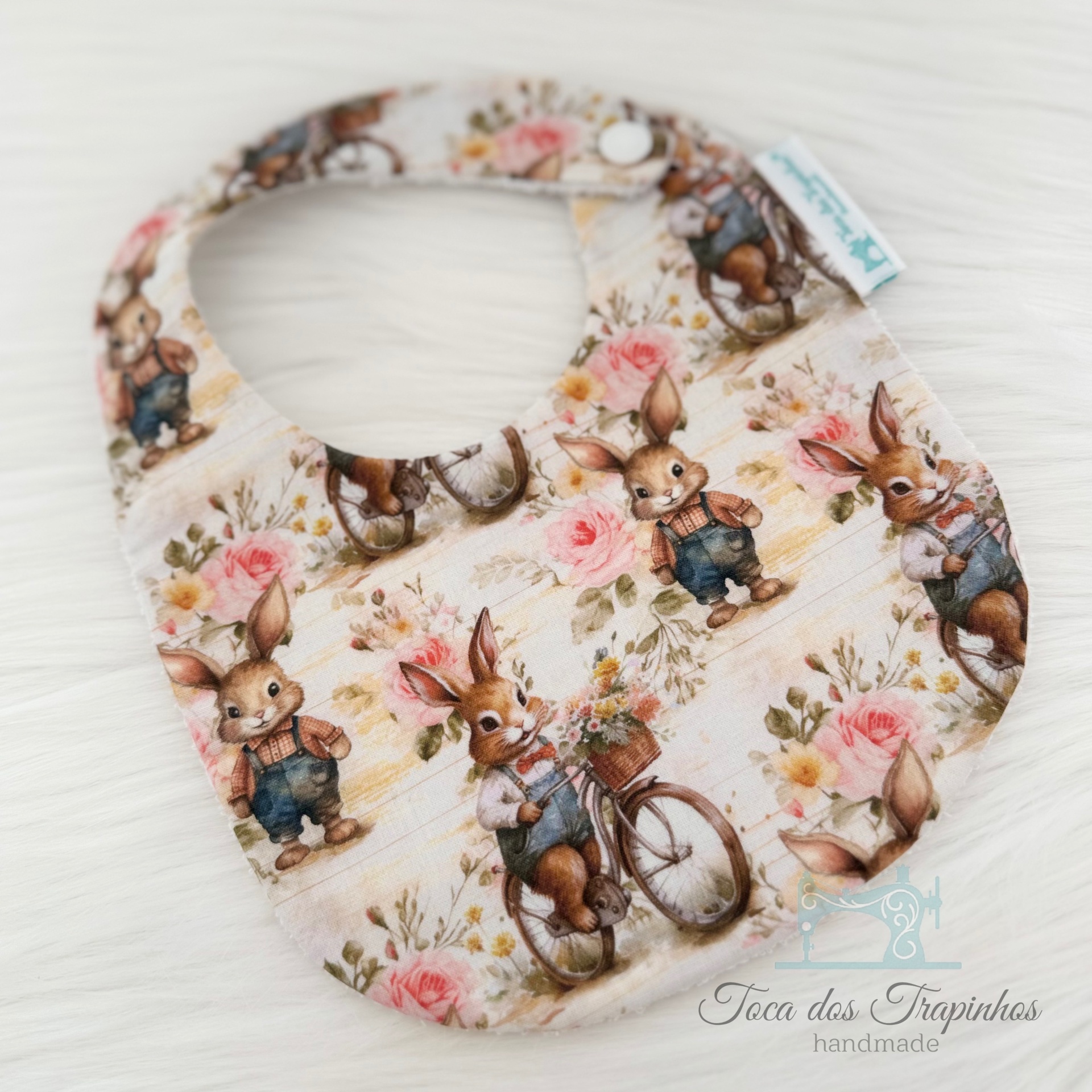 Babete bebé com padrão de coelhos e flores em tecido bege