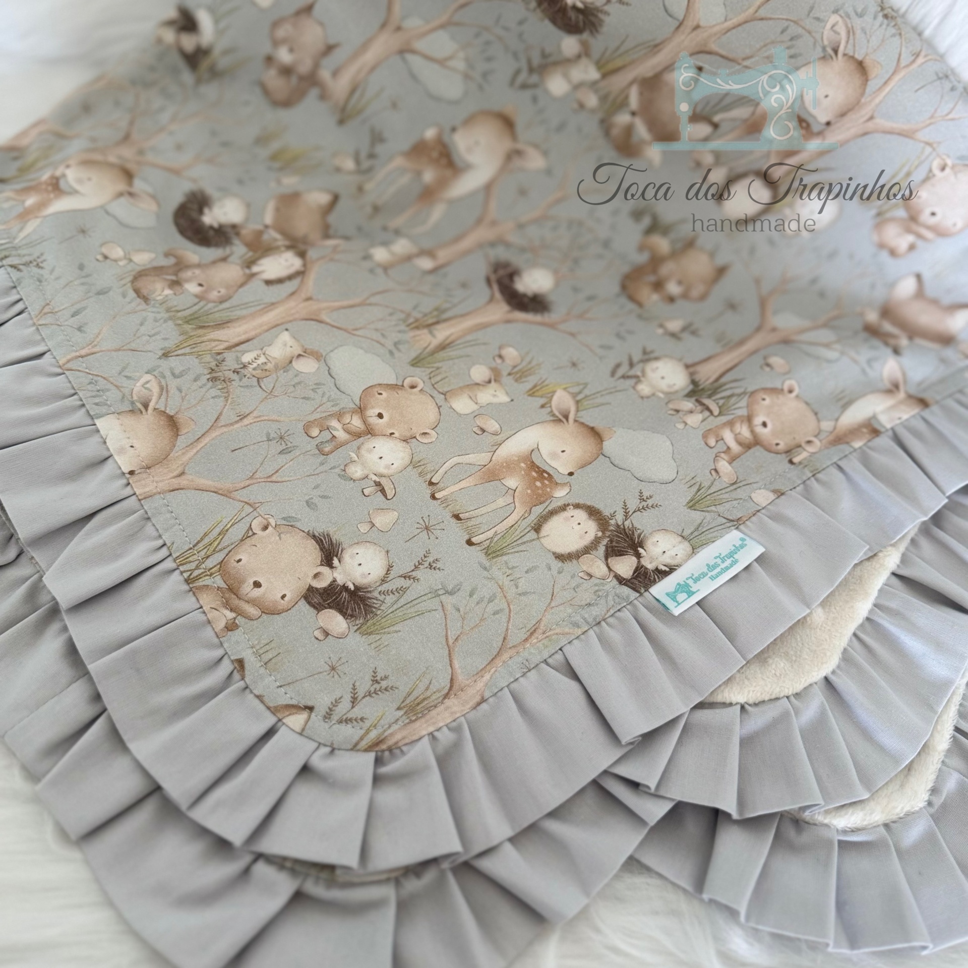 Manta para bebé com padrão de animais e borda plisada cinzenta