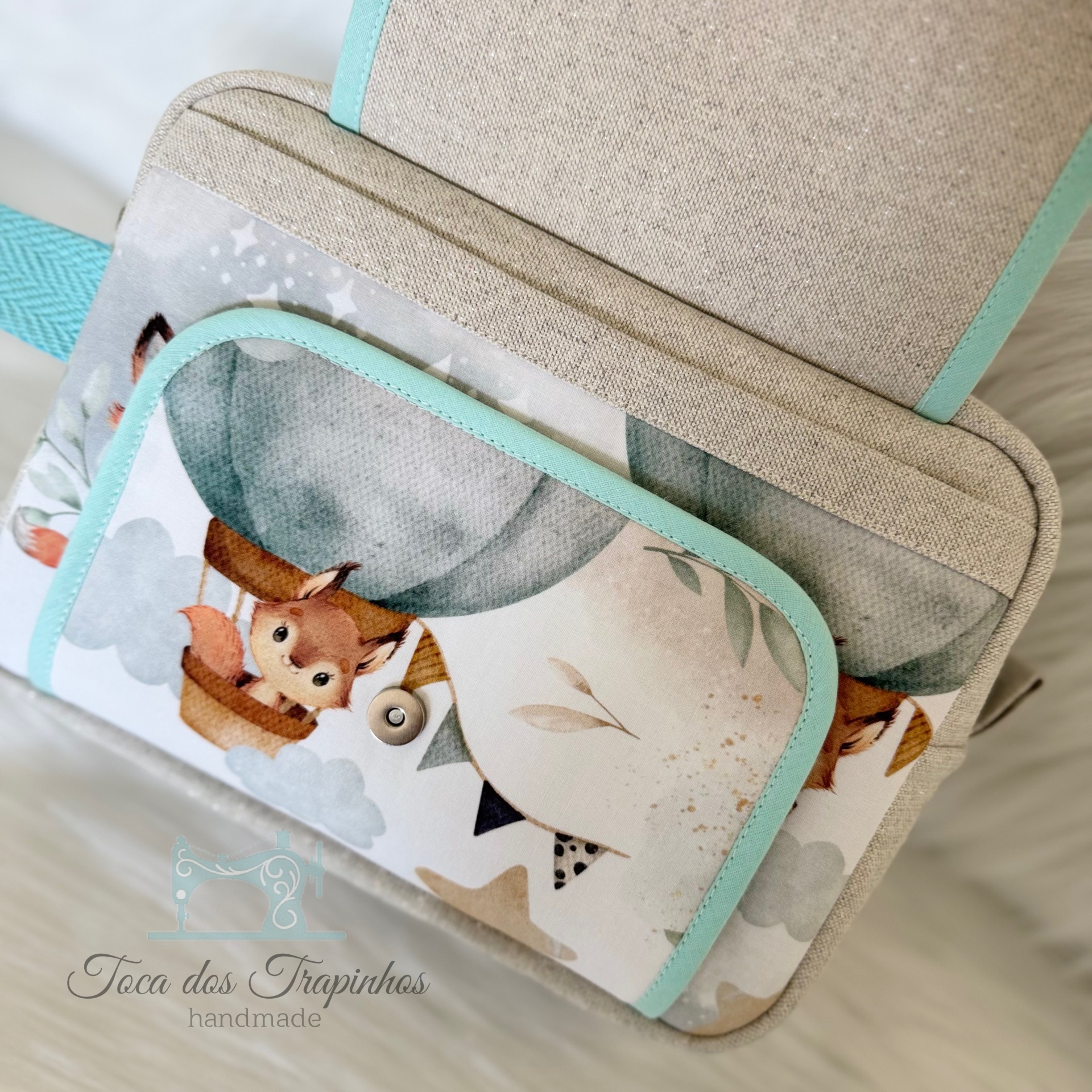 Bolsa infantil bege com personagens e detalhes azuis claros