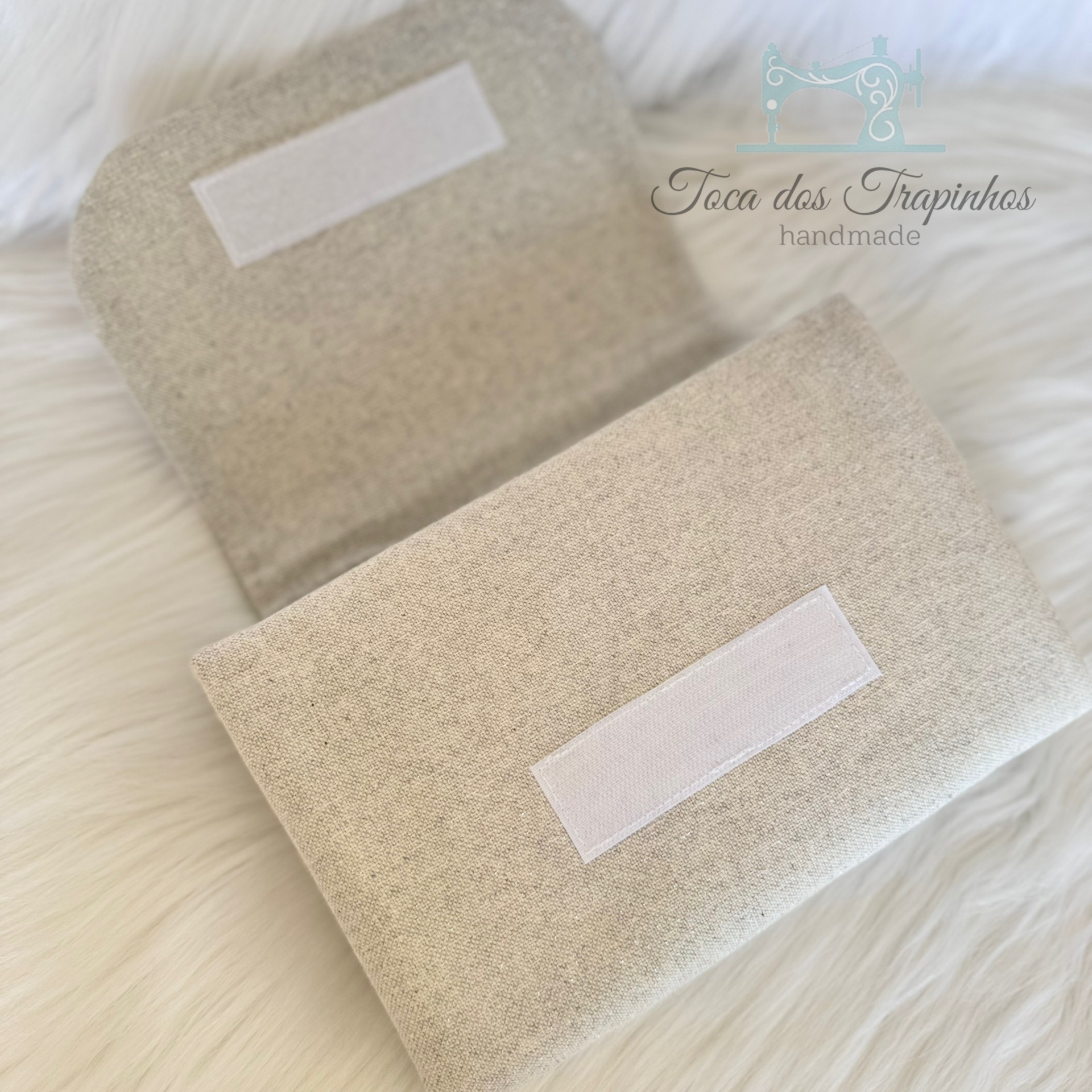 Carteira artesanal bege em tecido com fecho de velcro branco sobre superfície macia branca