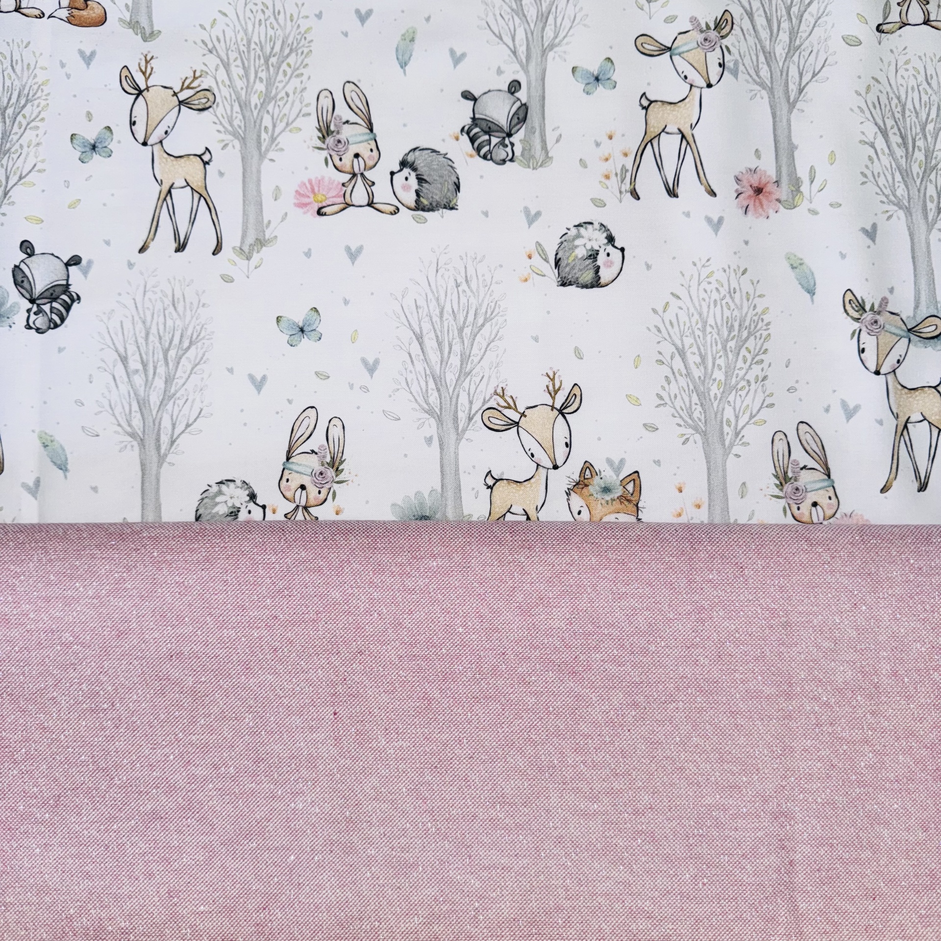 Tecidos infantil com animais estampados e tecido rosa liso.