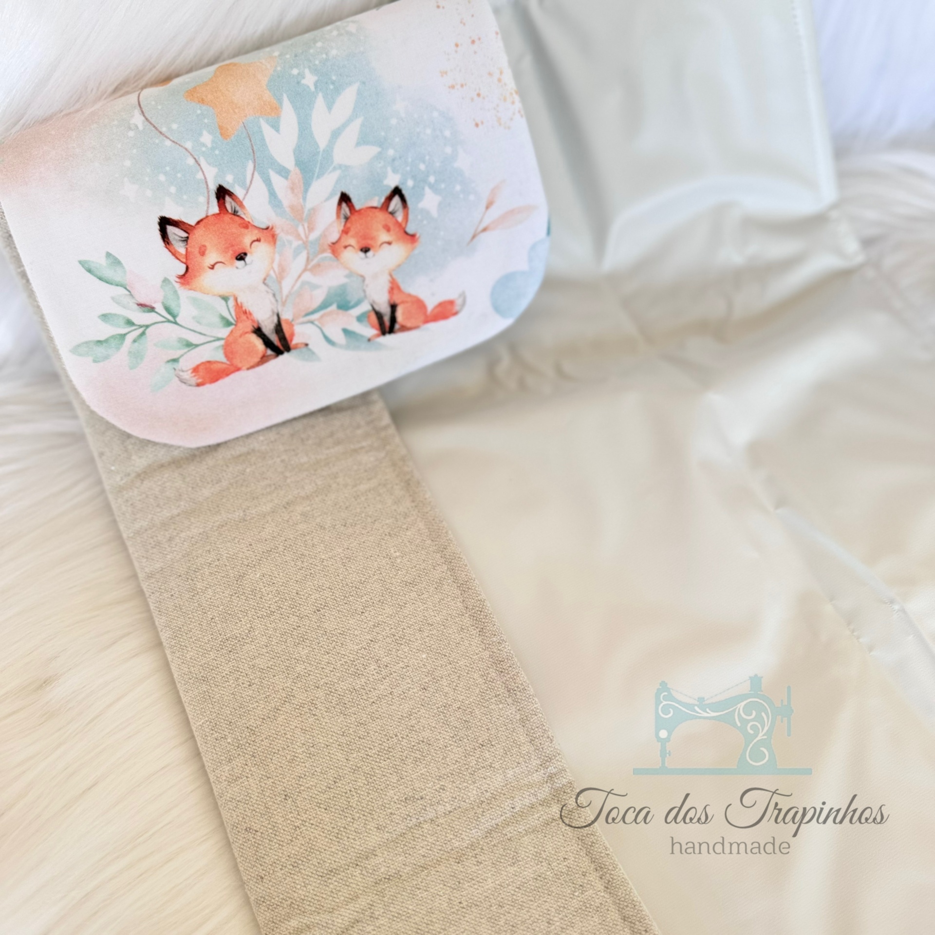 Manta de tecido cru com almofada decorativa azul e estampa de raposas