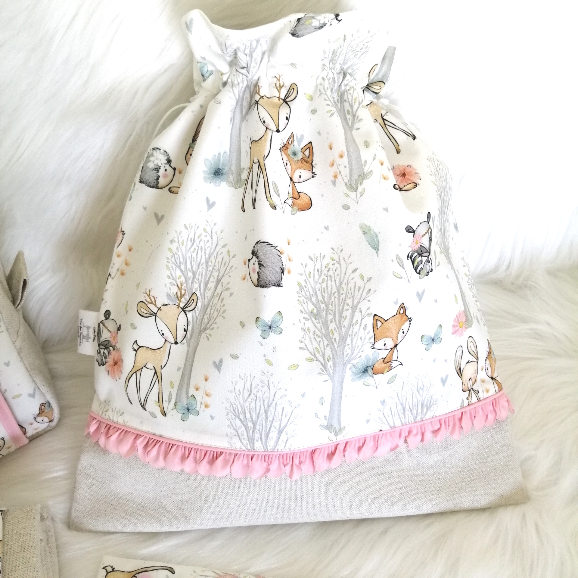 Saco tecido para bebé com padrão de animais da floresta e faixa rosa com pompons