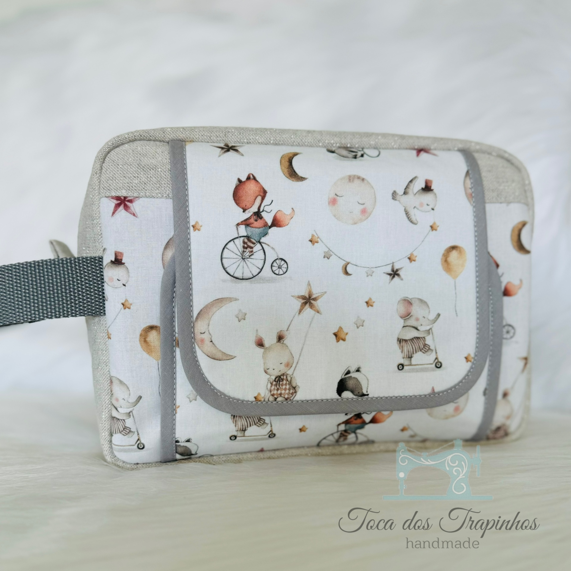 Bolsa multiusos com padrão de animais e estrelas em tecido branco e cinza.
