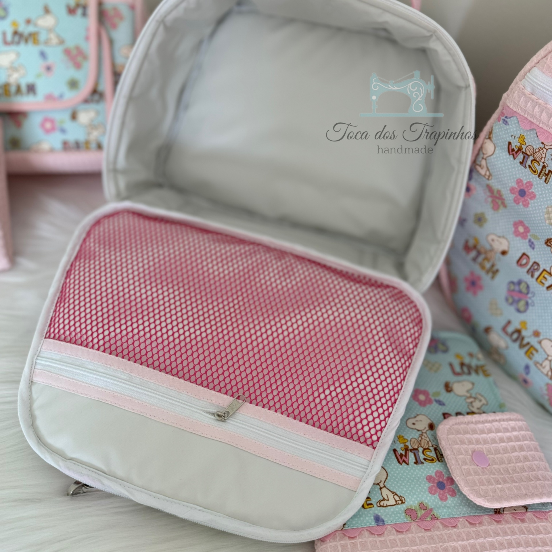 Mala ou mochila colorida com padrão de corações, interior cinza com bolso de rede rosa