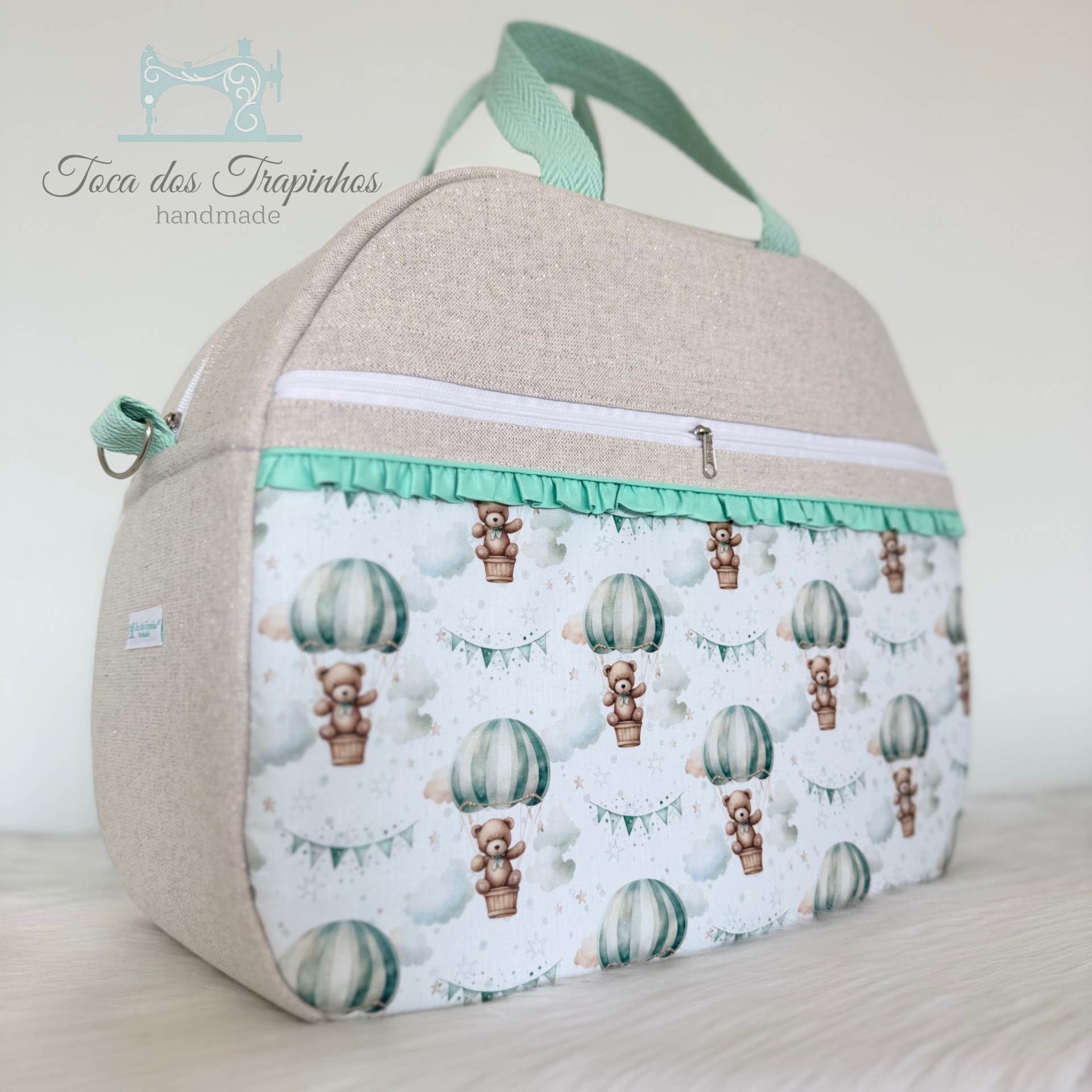 Mala de mão bege com bolso estampado de ursinhos em balões e alças verde água