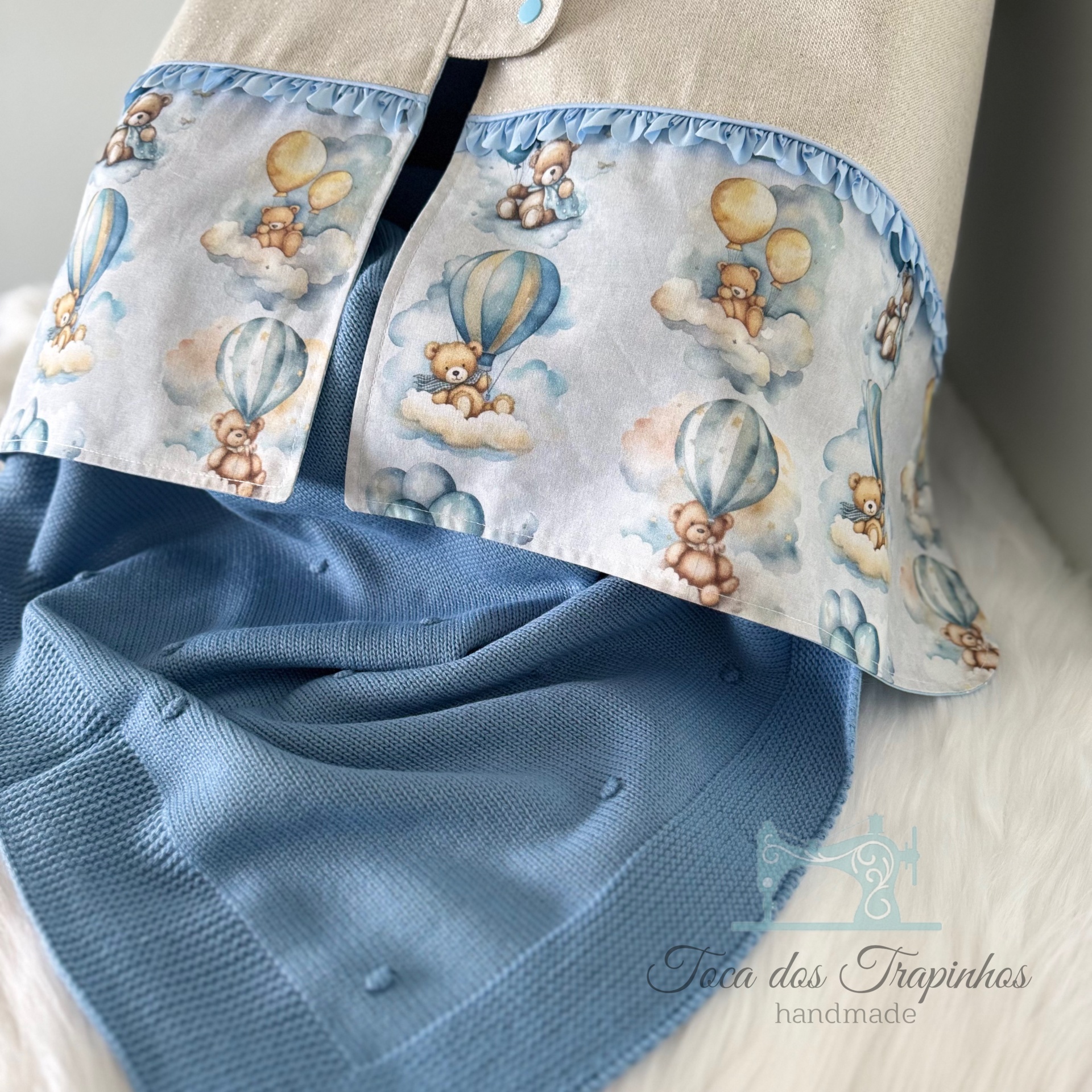 Cobertor cinza com barra decorada de tecido com padrão de ursinhos e manta azul de malha