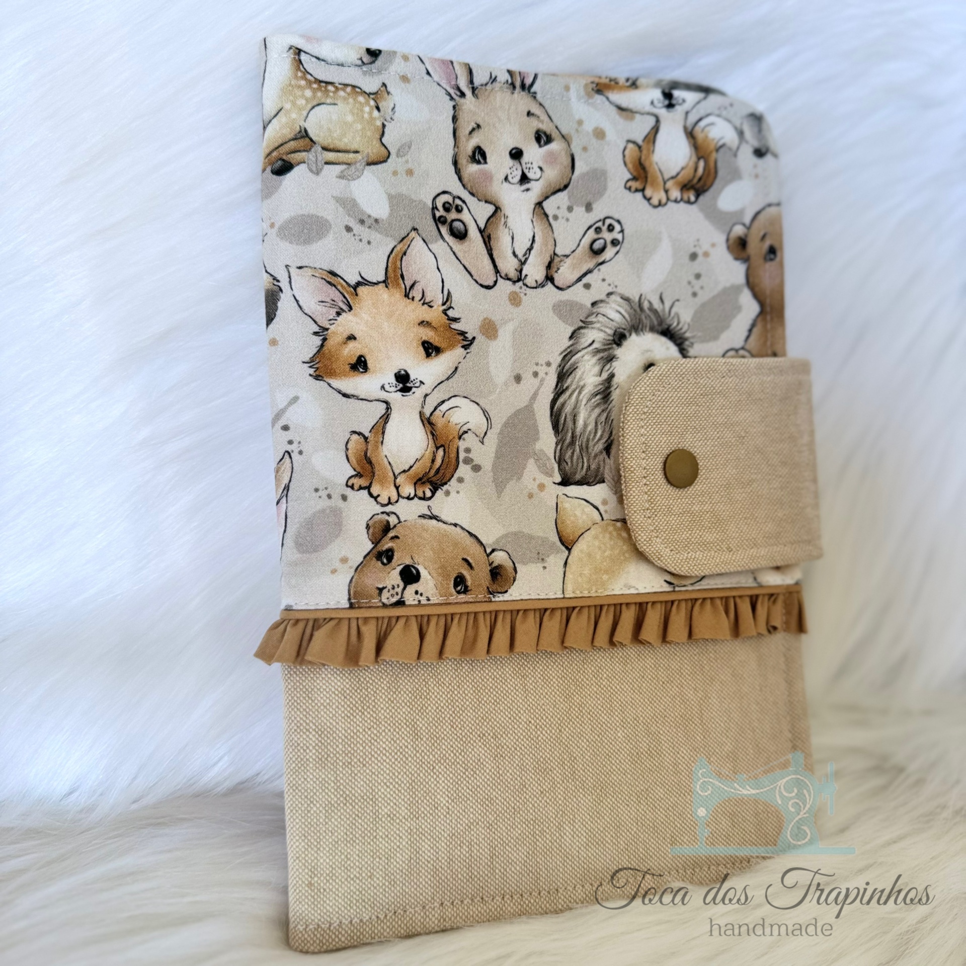 Capa de tecido para livro com padrão de animais e aba de fecho em tecido bege