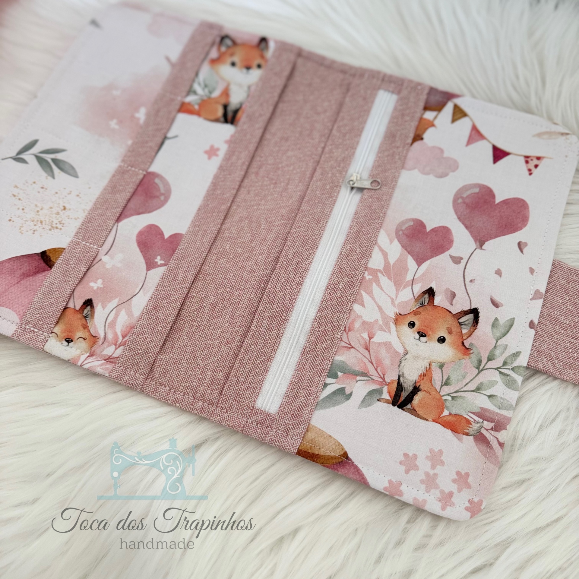 Carteira de tecido rosa com padrão de raposas e bolso com fecho
