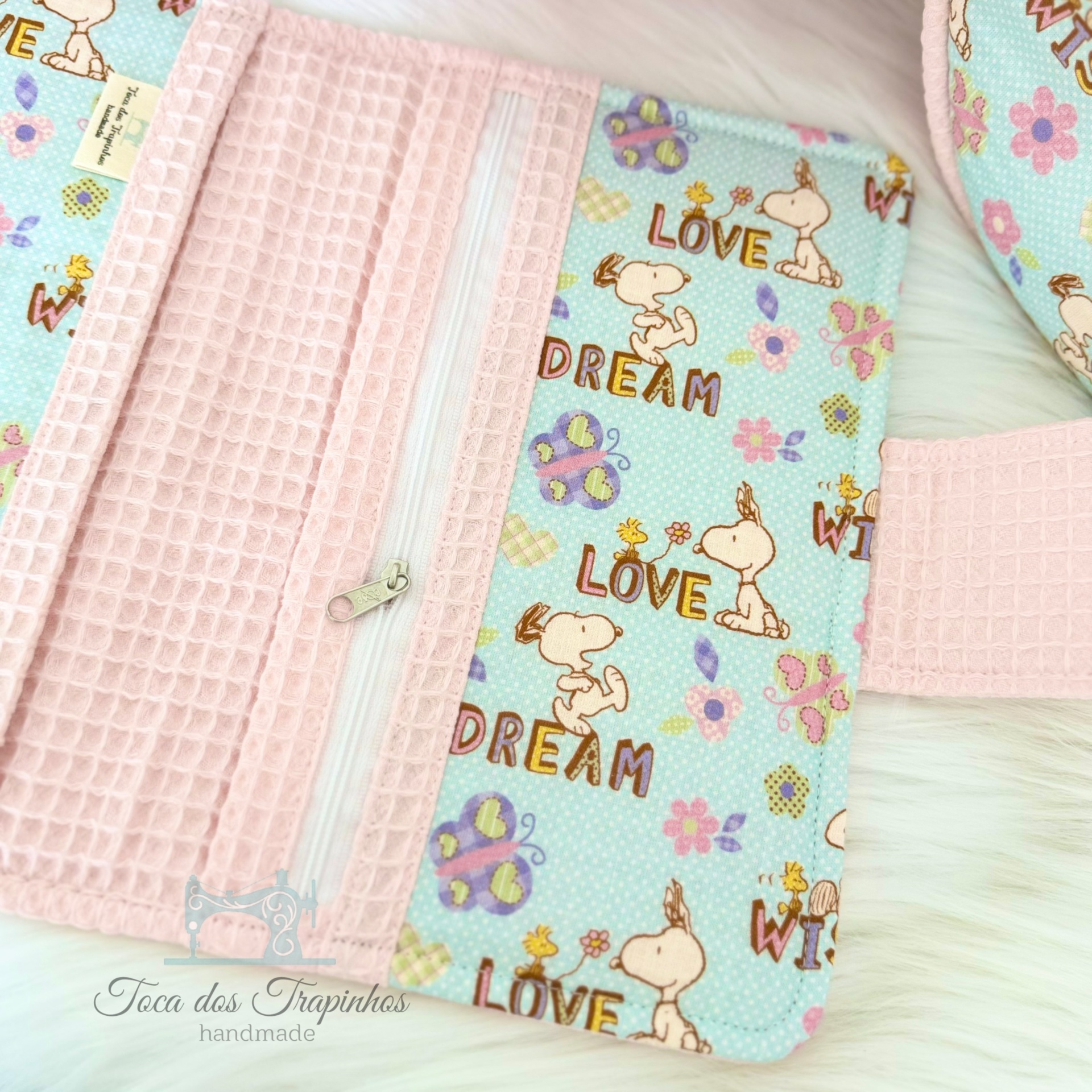 Carteira rosa com padrão com personagens e fecho de correr branco