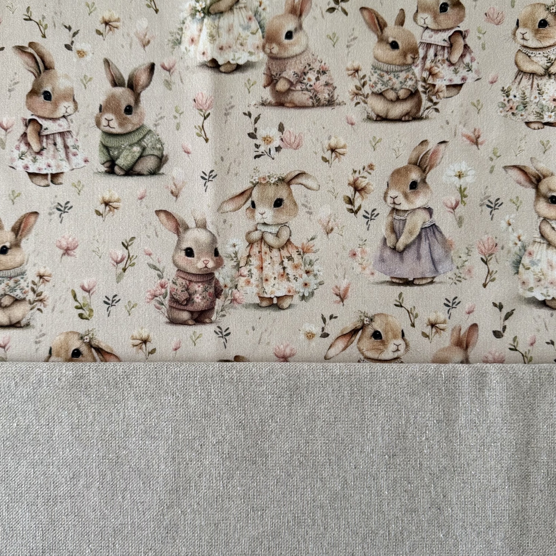 tecido estampado com coelhos vestidos tons pastel e tecido cinza liso