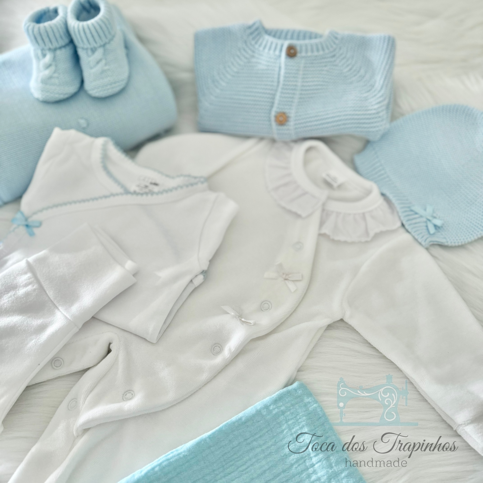 Conjunto de roupa de bebé azul e branco com sapatinhos, casaco, body, touca e manta