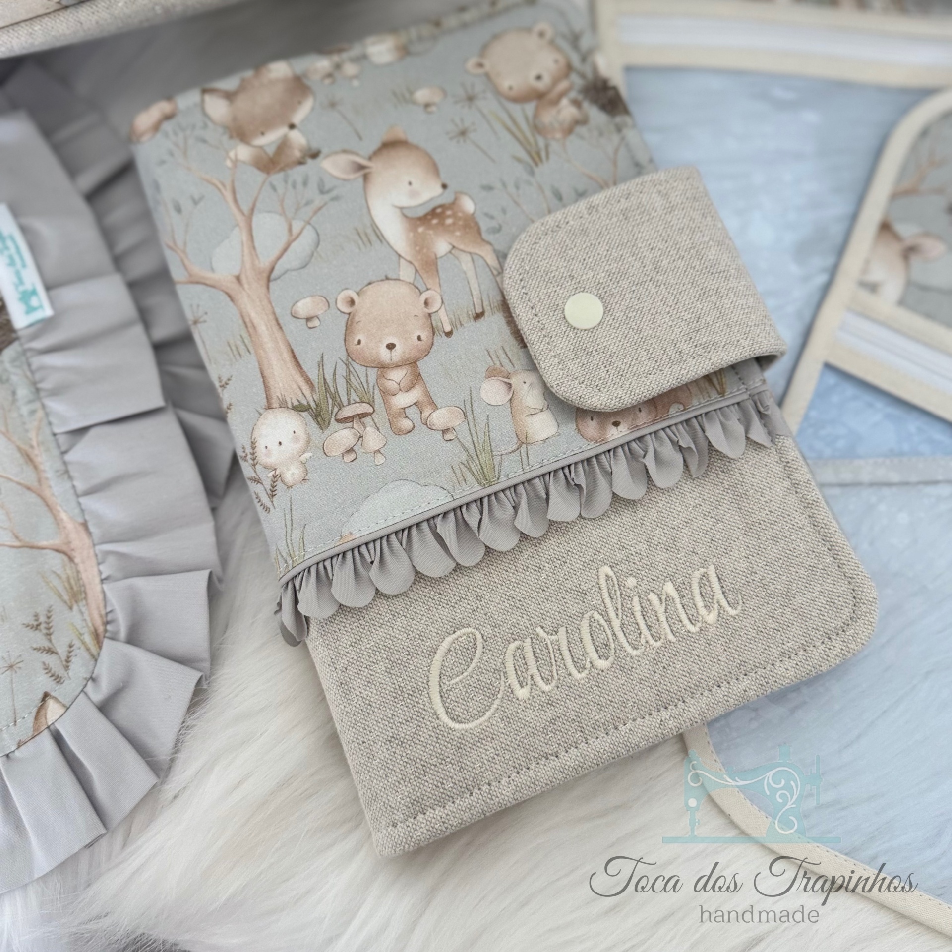 Capa de tecido com padrão de animais e nome Carolina bordado