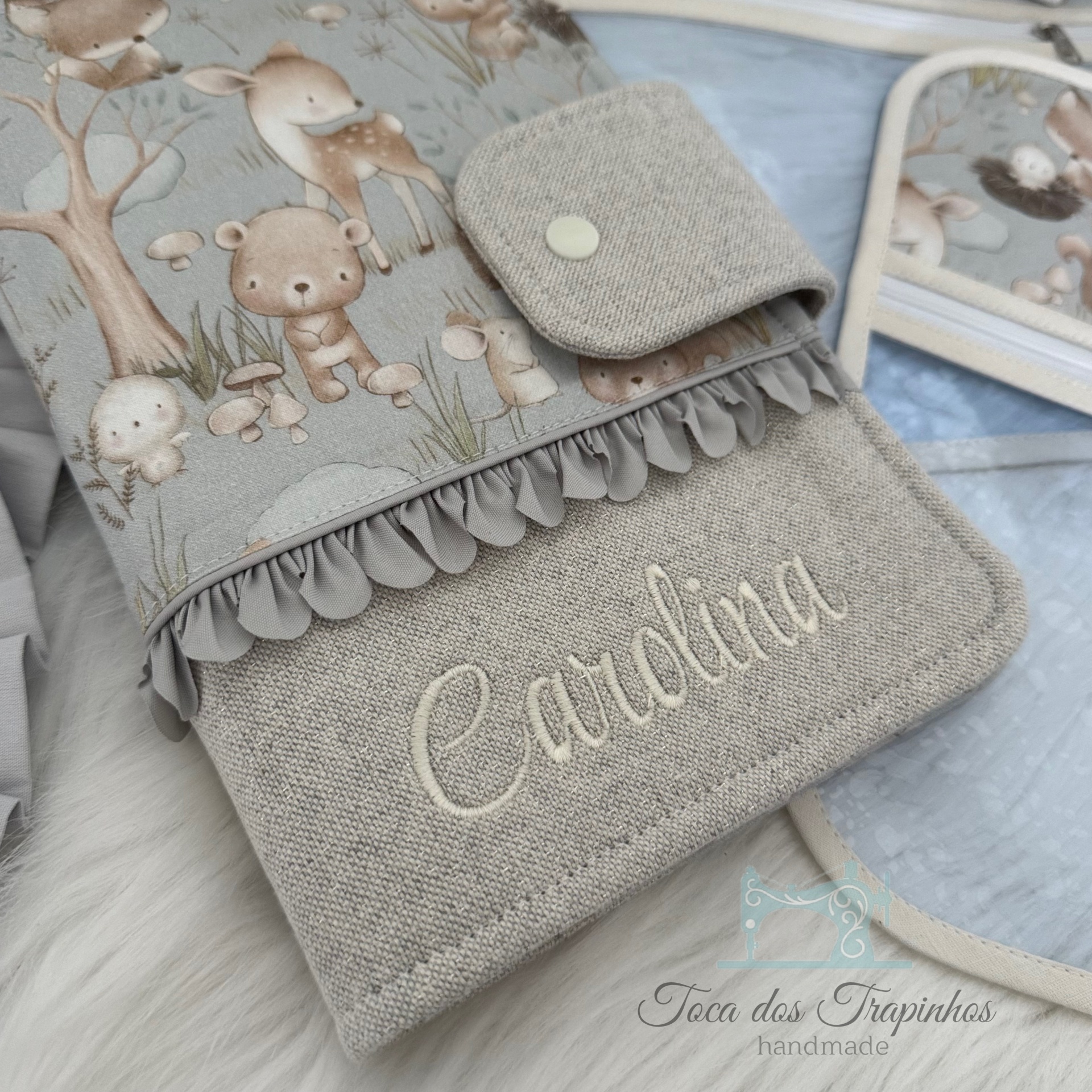 Capa de tecido cinza com estampa infantil e nome Carolina bordado
