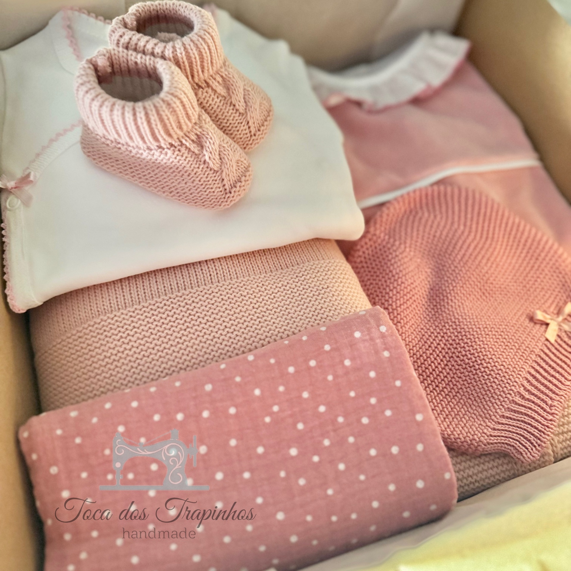 Conjunto de roupa rosa para bebé em caixa com sapatinhos, camisola, manta e logótipo