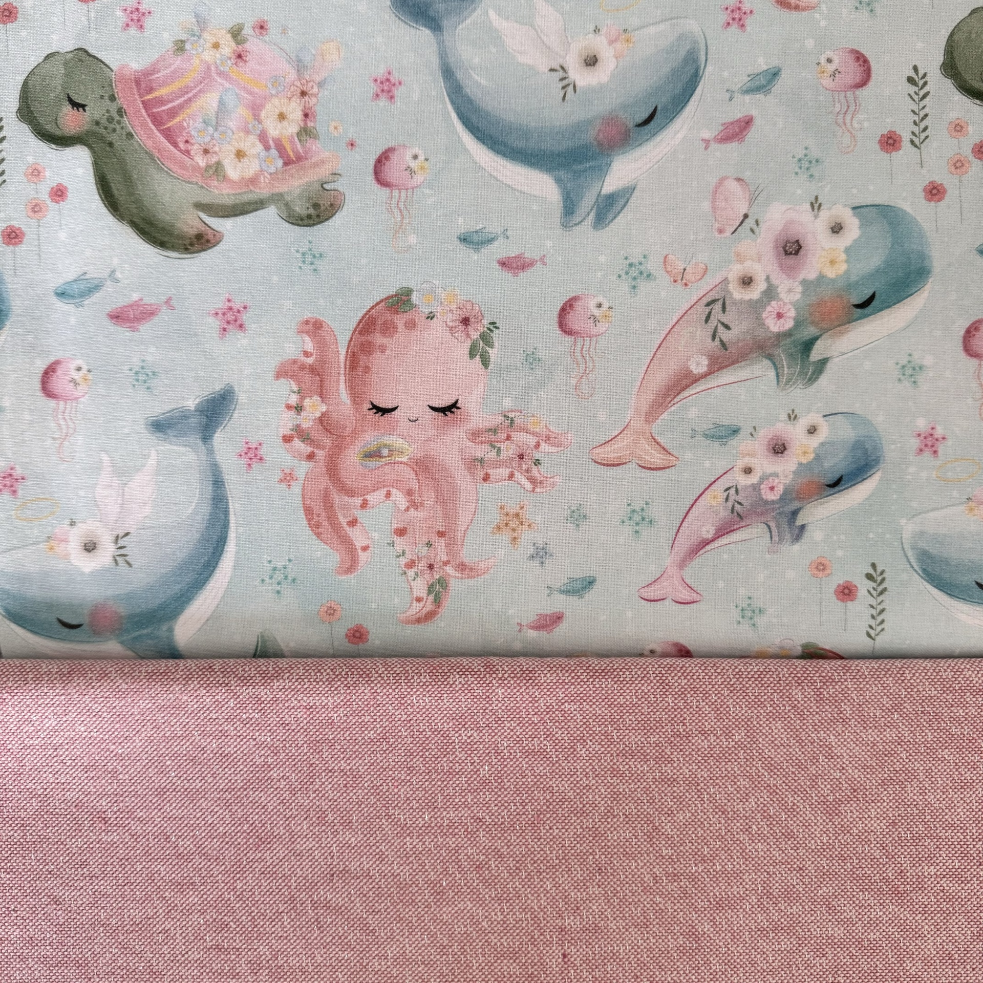 tecido infantil com animais marinhos coloridos e tecido rosa texturizado