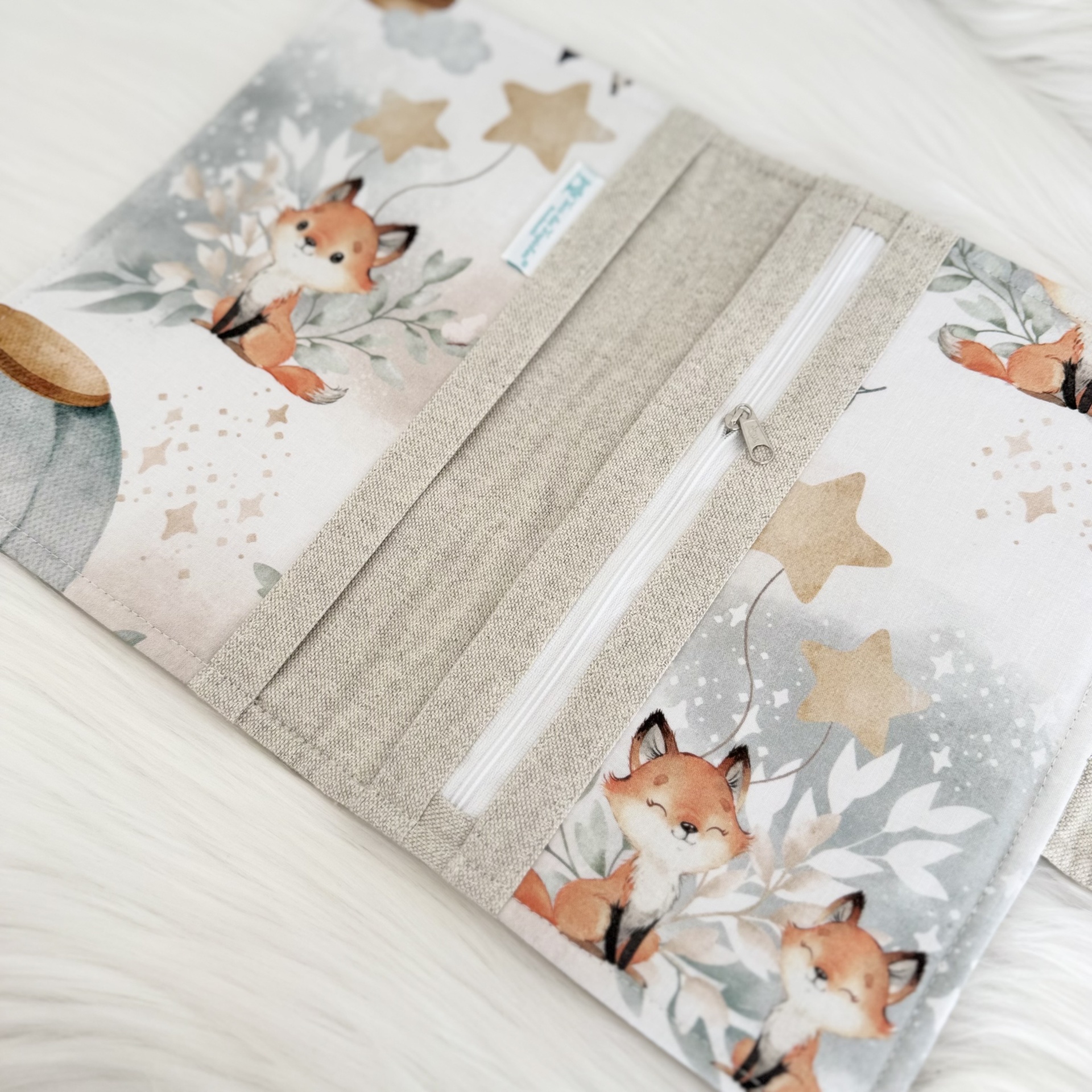 Têxtil com estampado de raposas, estrelas e fecho branco