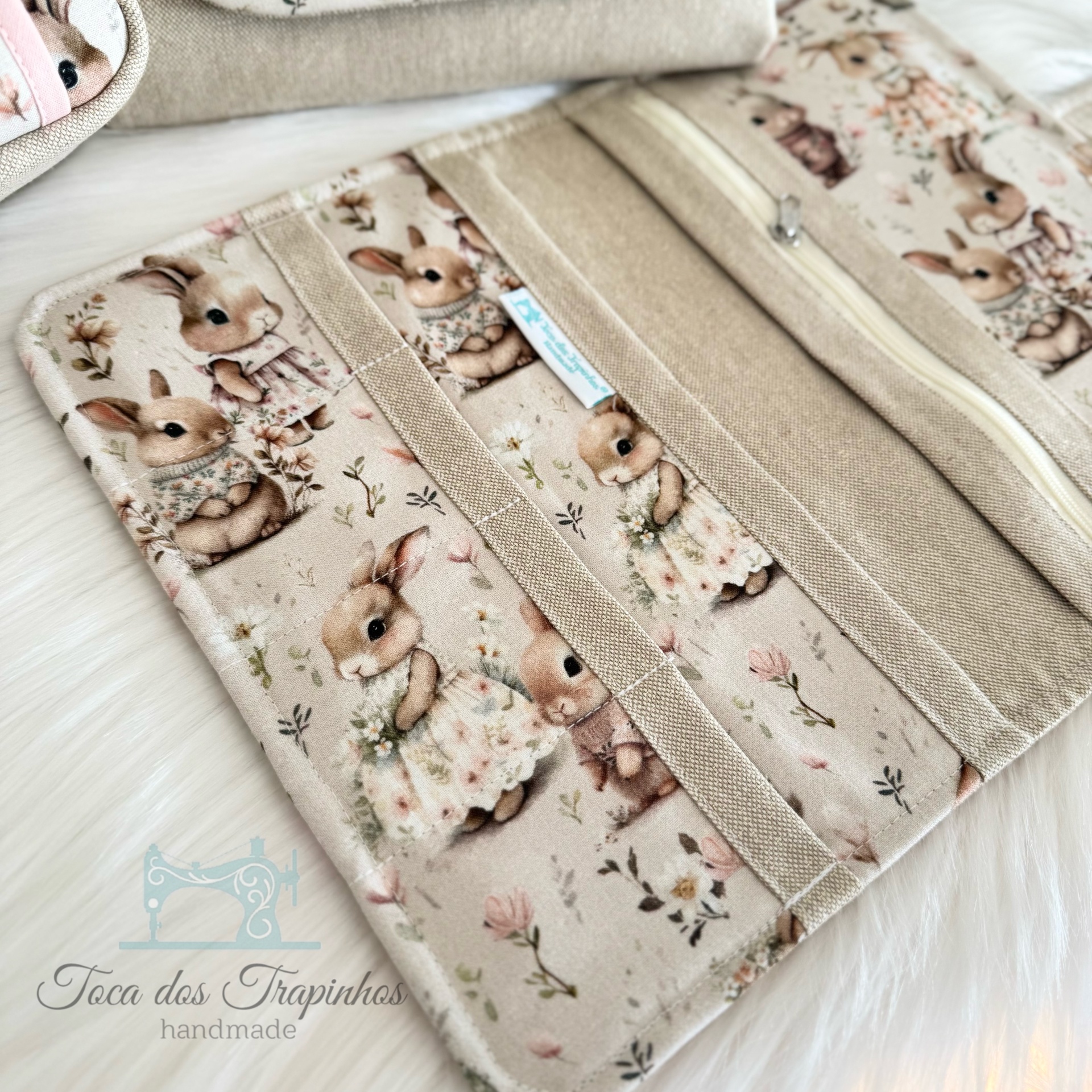 Organizador de tecido com padrão de coelhinhos e flores em tons suaves.