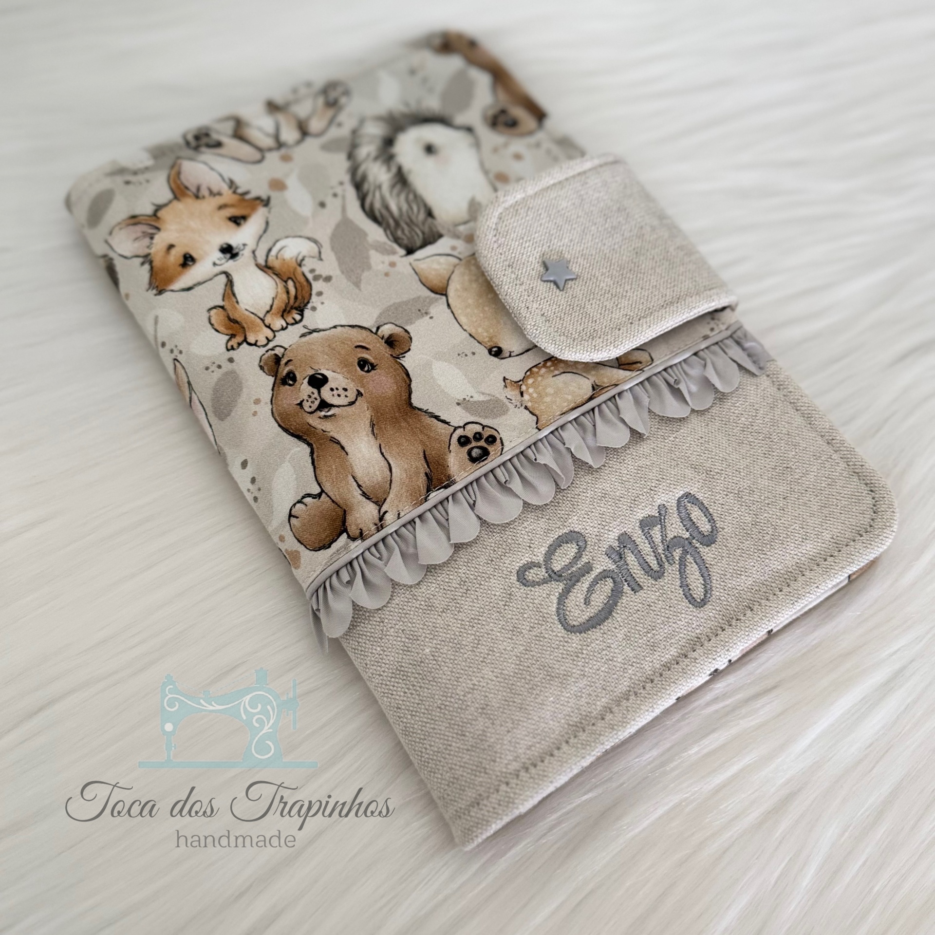 Capa de tecido decorada com animais e nome Enzo bordado