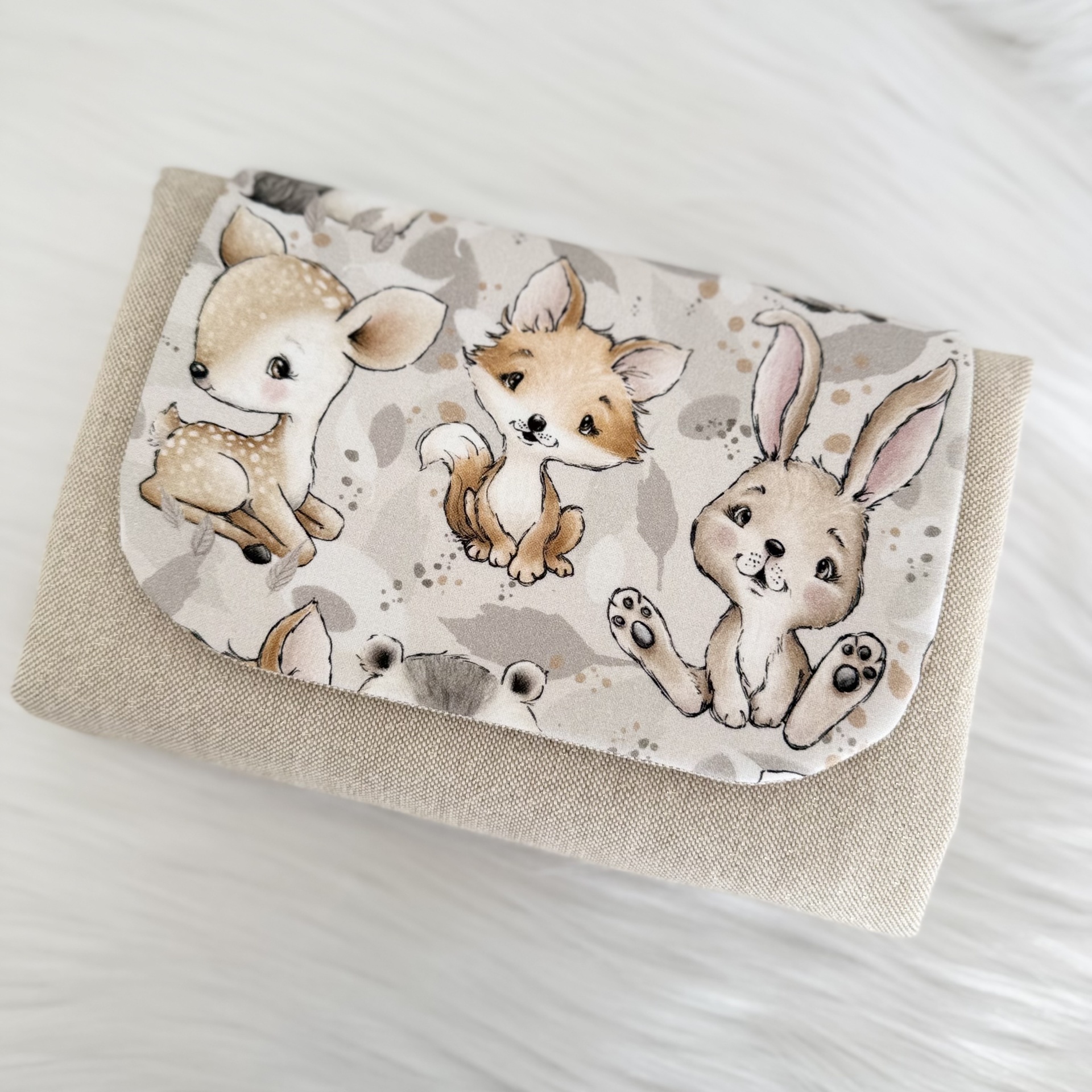 Bolsa em tecido bege com aba estampada com desenhos de animais baby