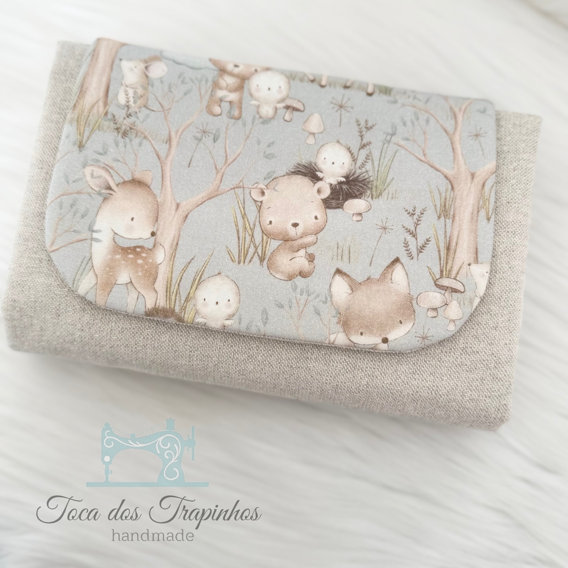 Carteira pequena em tecido cinza com aba estampada com animais pastéis