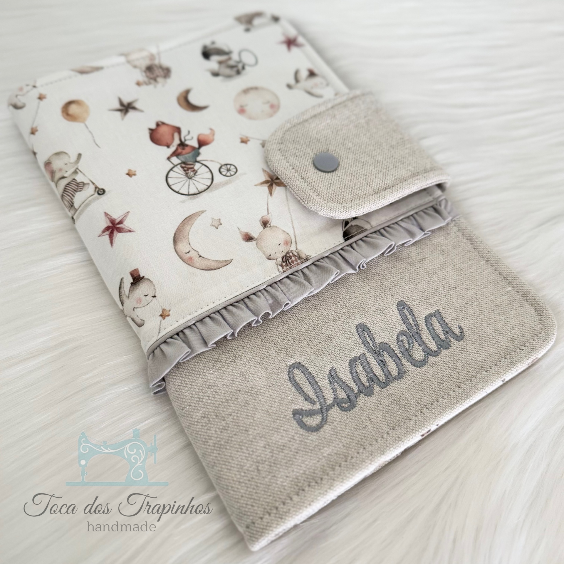 Capa de tecido com desenhos infantis e nome bordado