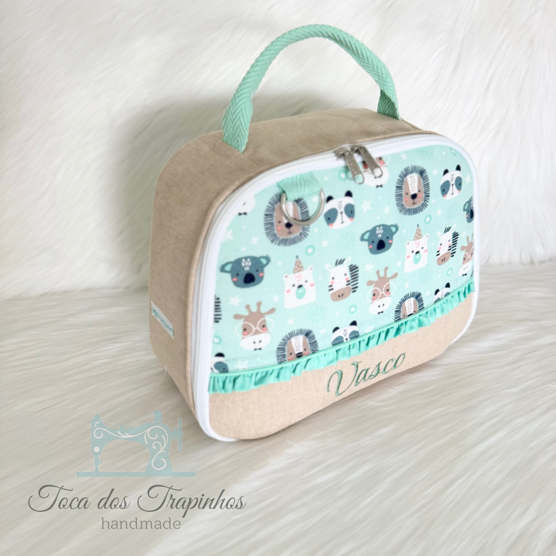 Bolsa azul claro com padrão de animais e nome Vasco bordado