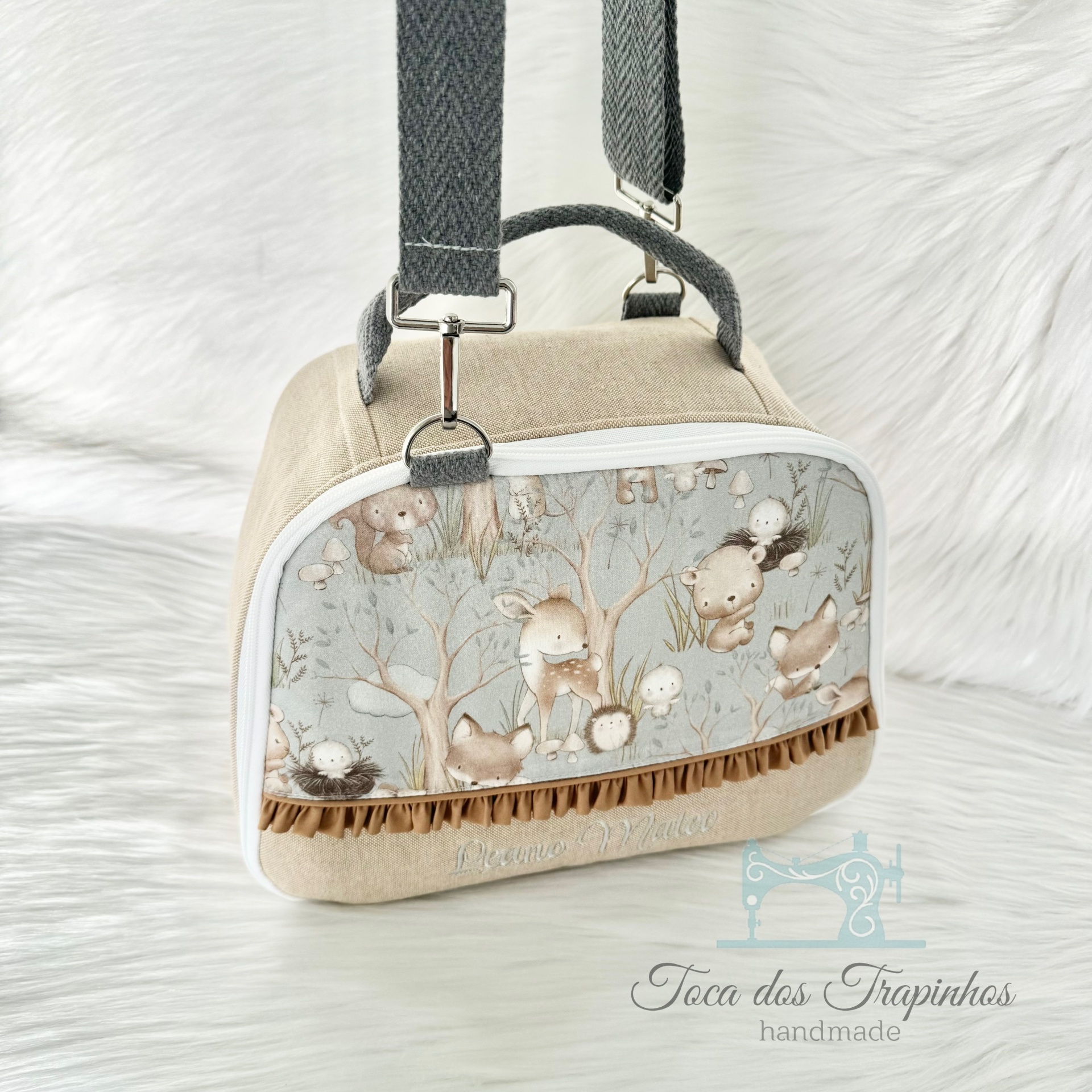 Mala pequena bege com alças cinzentas e estampa de animais da floresta