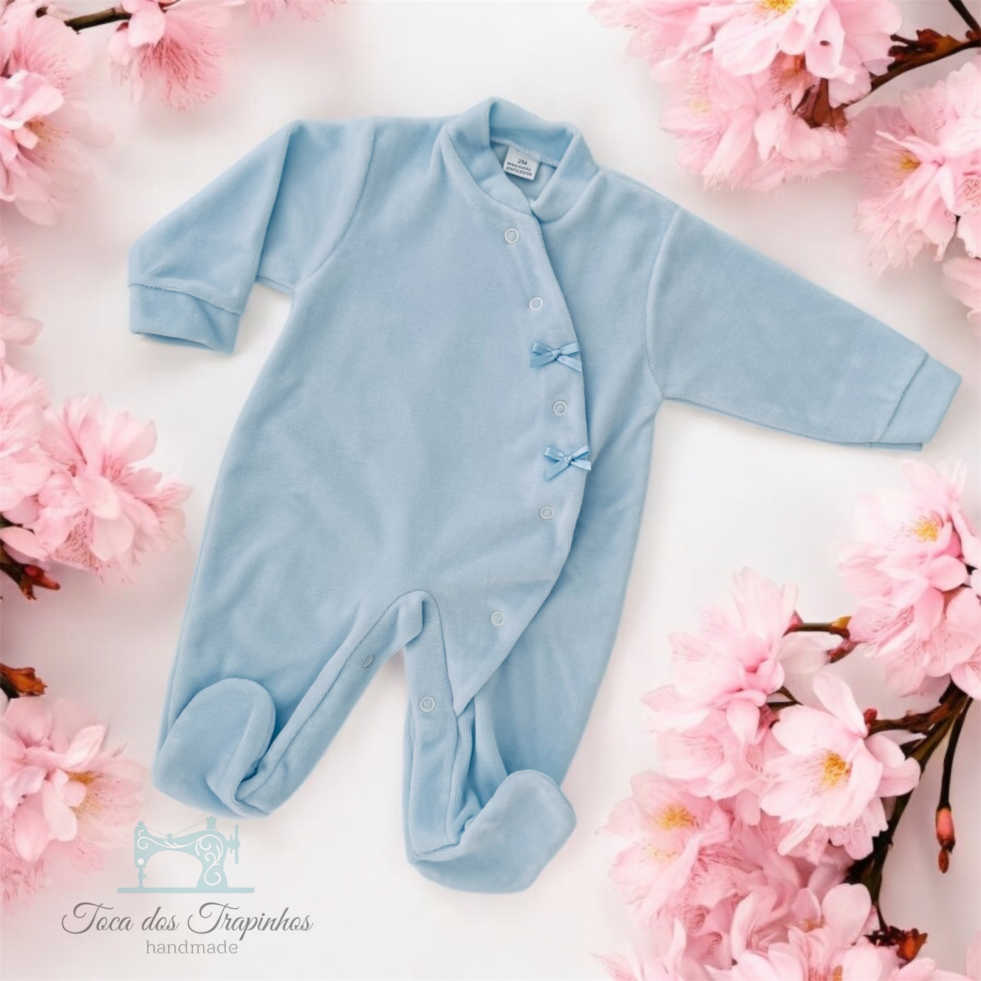 Macacão azul claro para bebé com botões e laços, decorado com flores cor-de-rosa