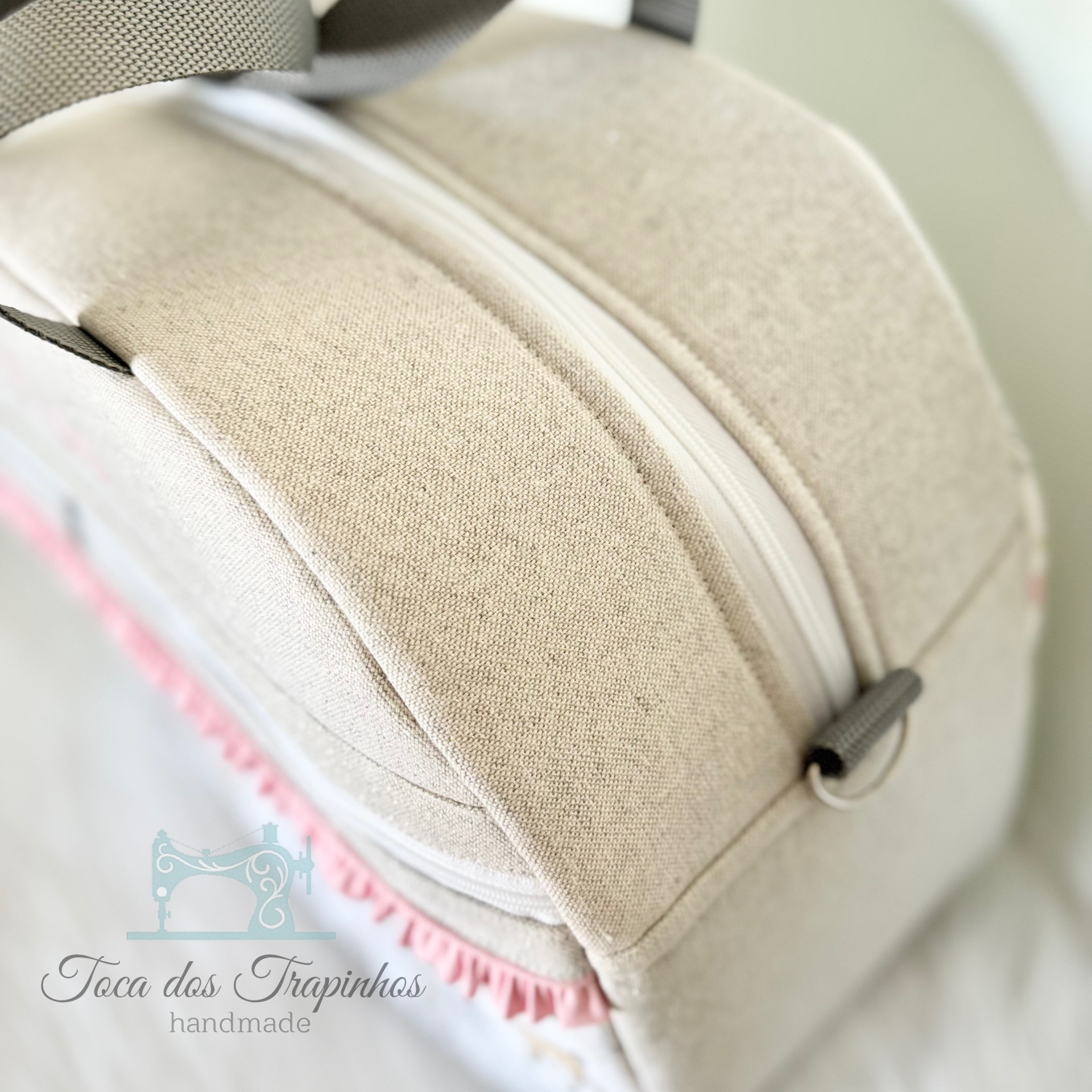 Bolsa de tecido bege claro com fecho branco e logótipo 'Toca dos Trapinhos handmade'