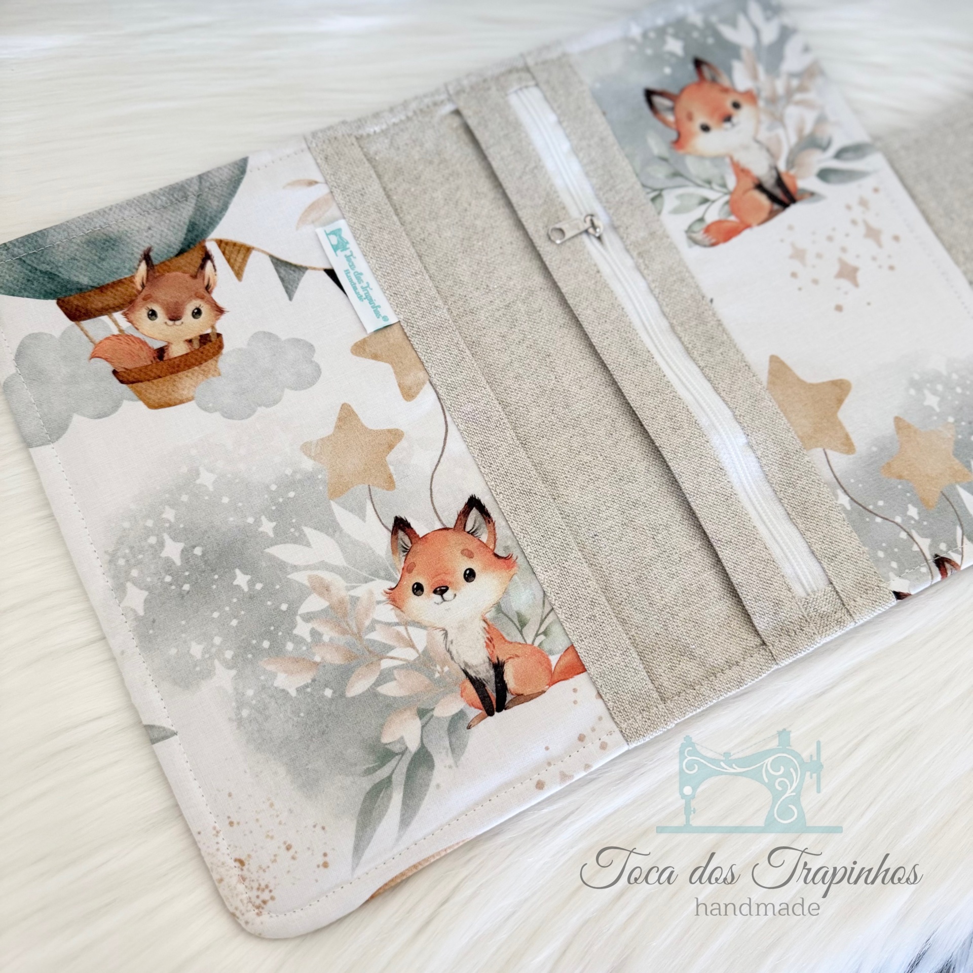 Capa de tecido com padrão de raposas e estrelas em tons neutros