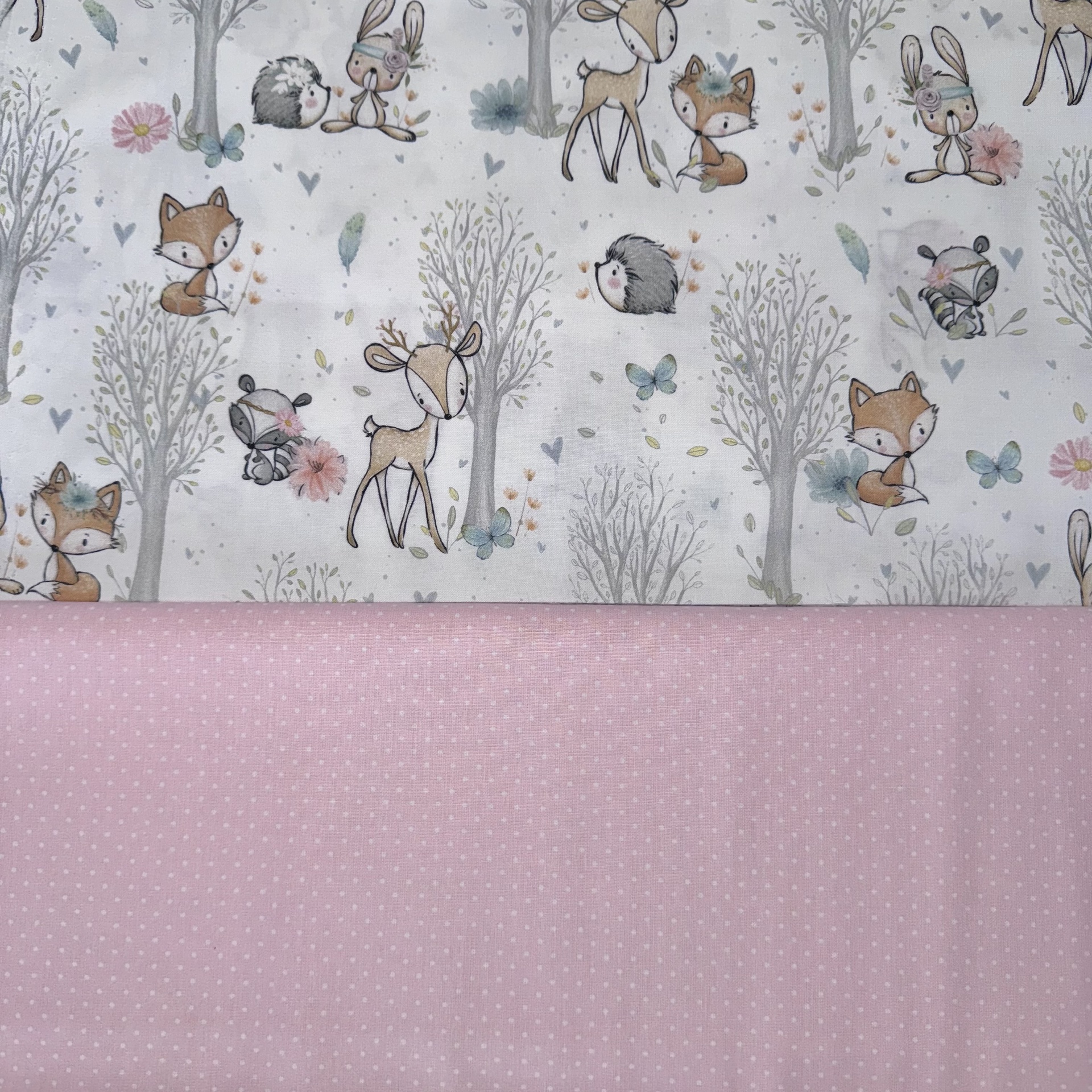 tecidos infantis com padrão de animais e tecido rosa com pontos brancos