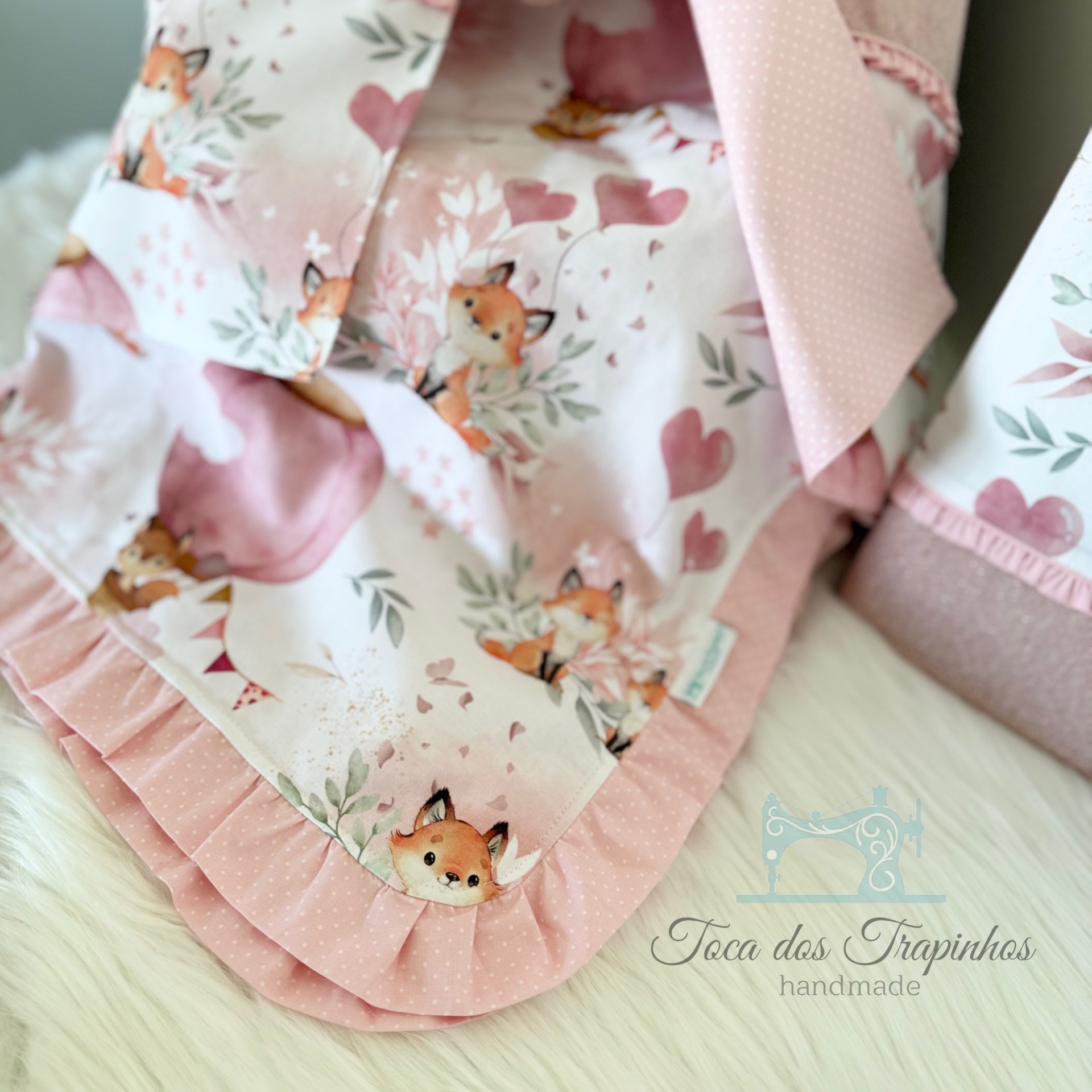 Manta de bebê rosa com padrão de raposas e corações e babados
