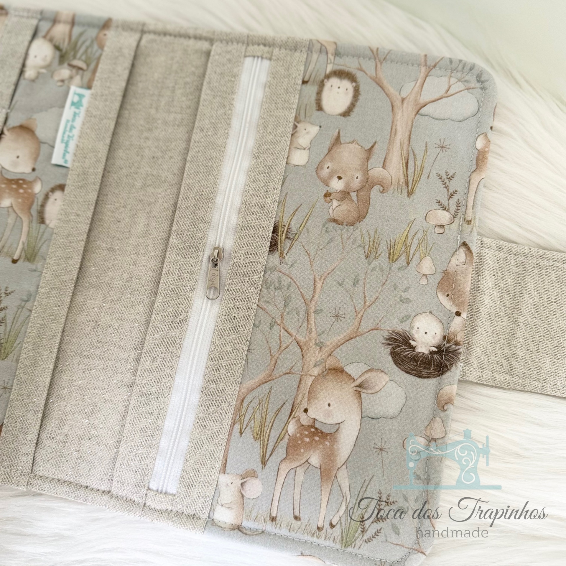 Carteira com estampa de animais em tons neutros e fecho de zíper