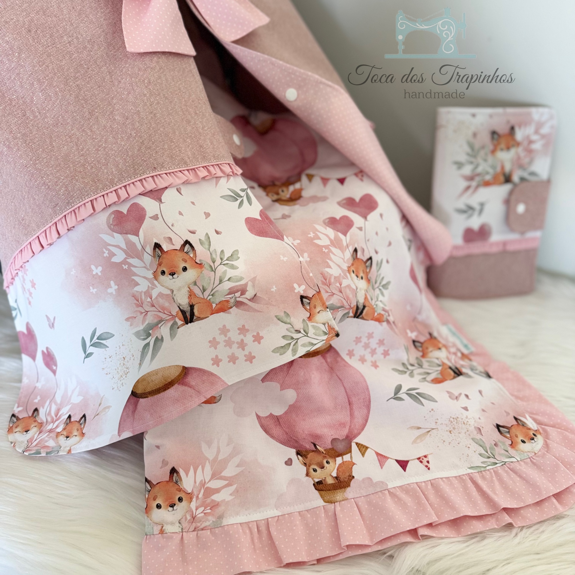 Conjunto de têxteis para bebé com padrão de raposinhas em tons de rosa com folhos