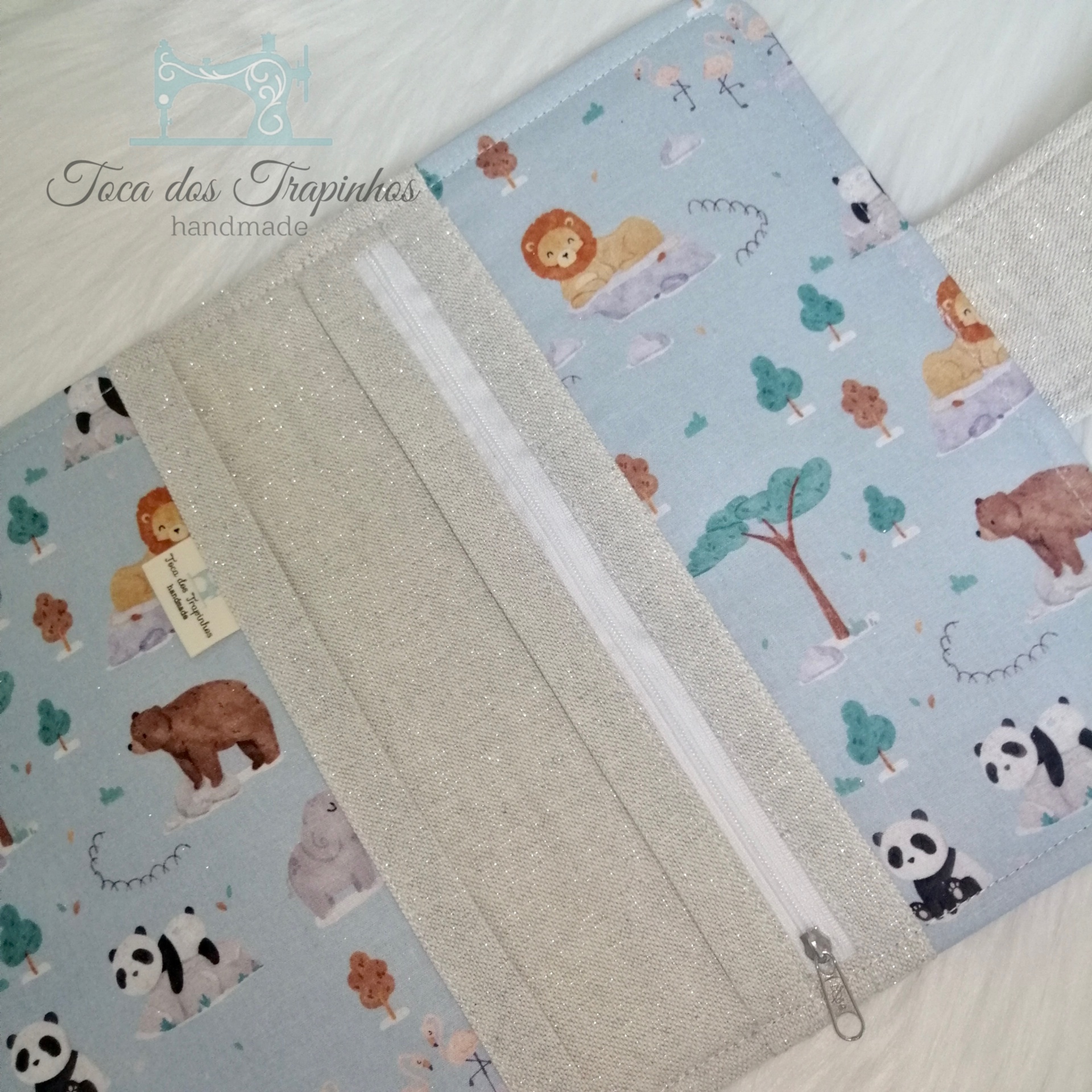 Carteira em tecido azul claro estampada com animais e fecho de correr bege