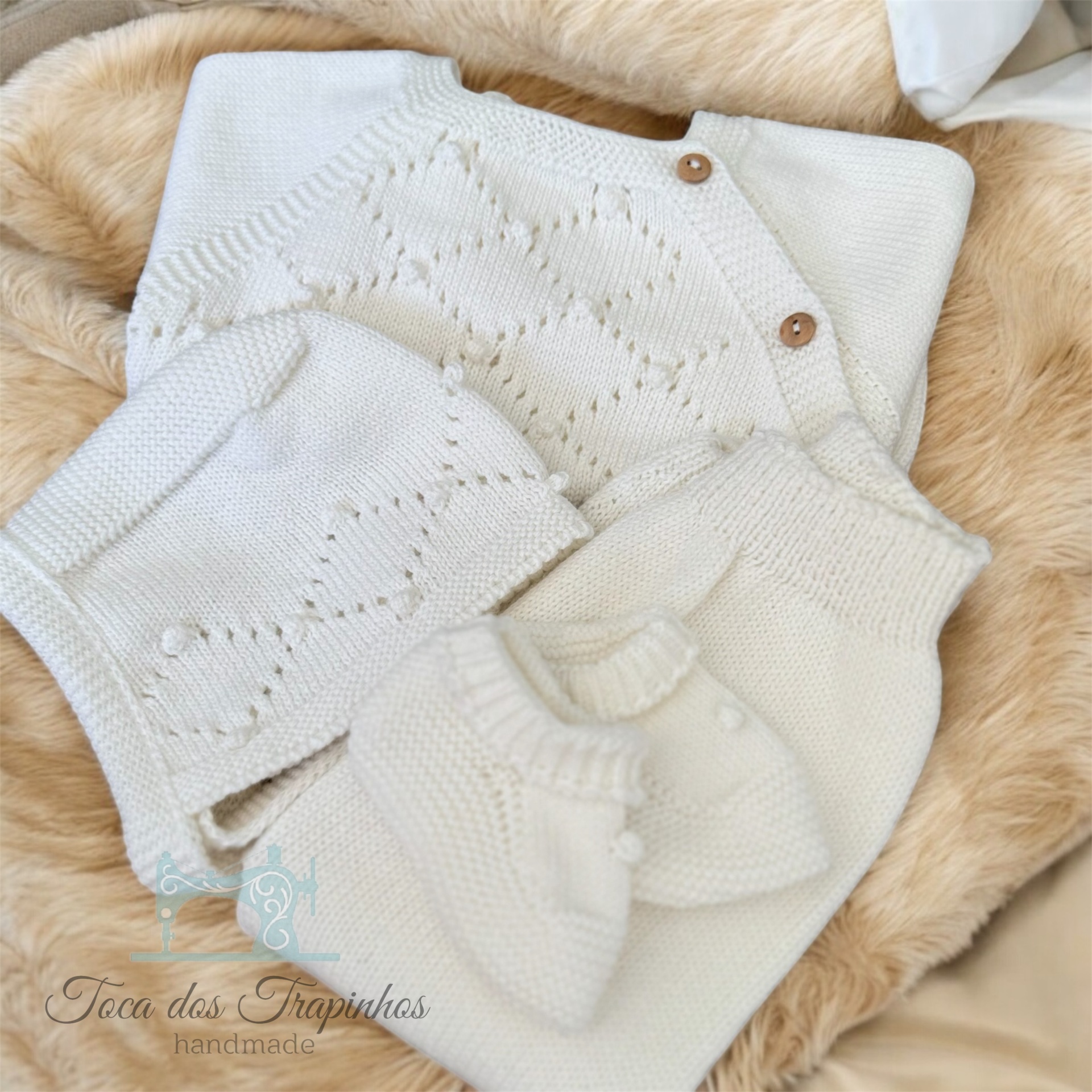 Conjunto de roupa de bebé branca em malha com casaco, gorro, botinhas e manta