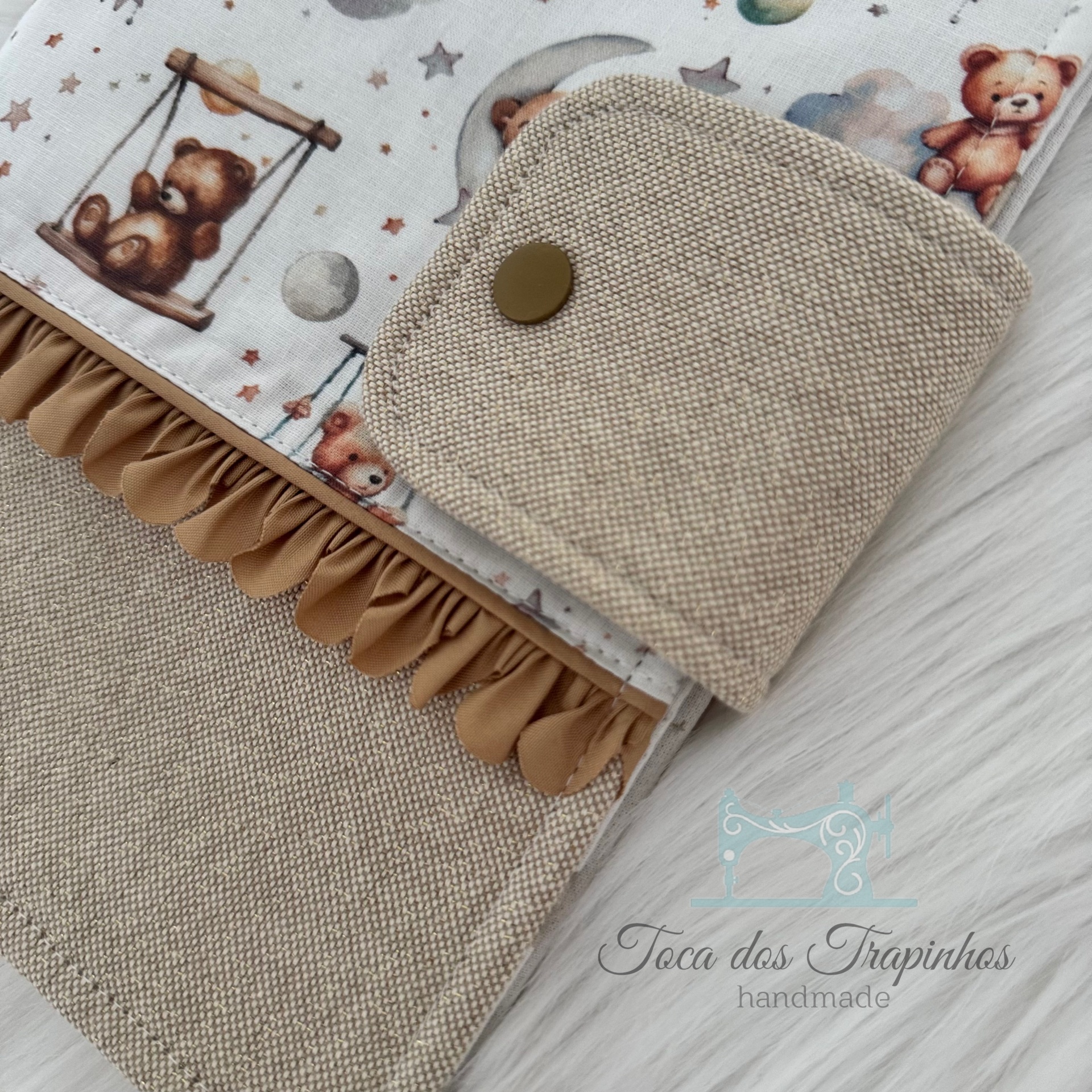 Carteira ou estojo de tecido bege com botão e detalhe estampado de ursos